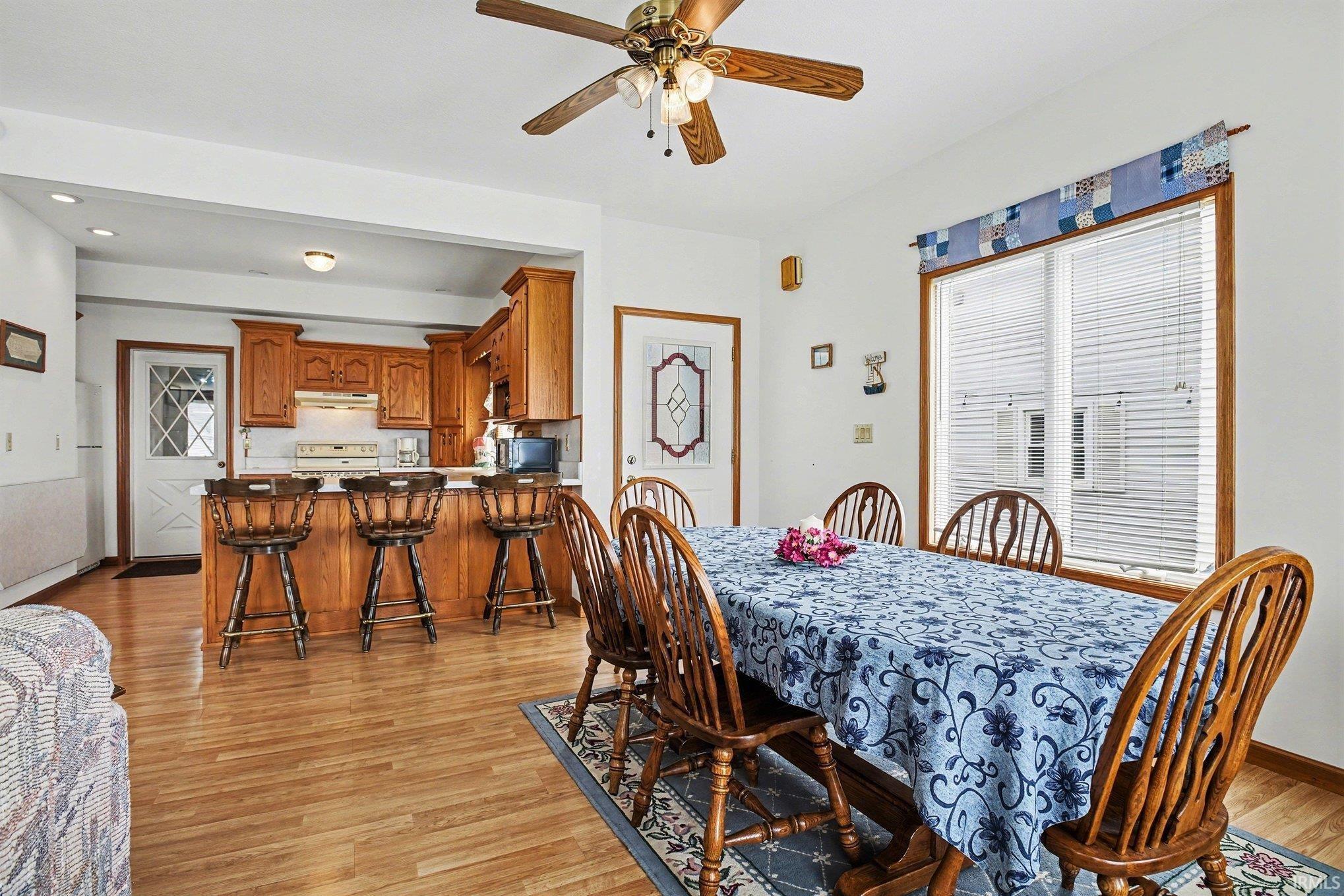 Dining area featuring ceiling fan, light wood finished floors, and recessed lighting