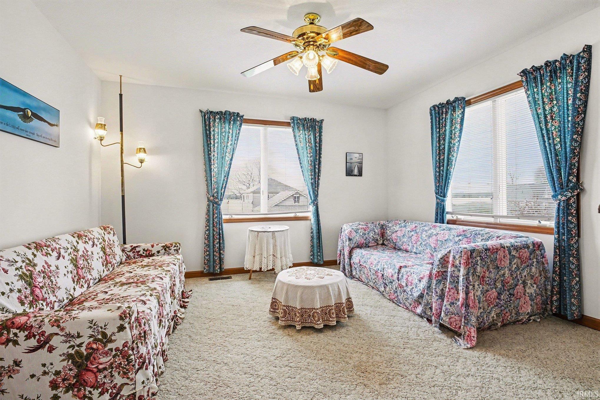 Sitting area featuring carpet floors and ceiling fan