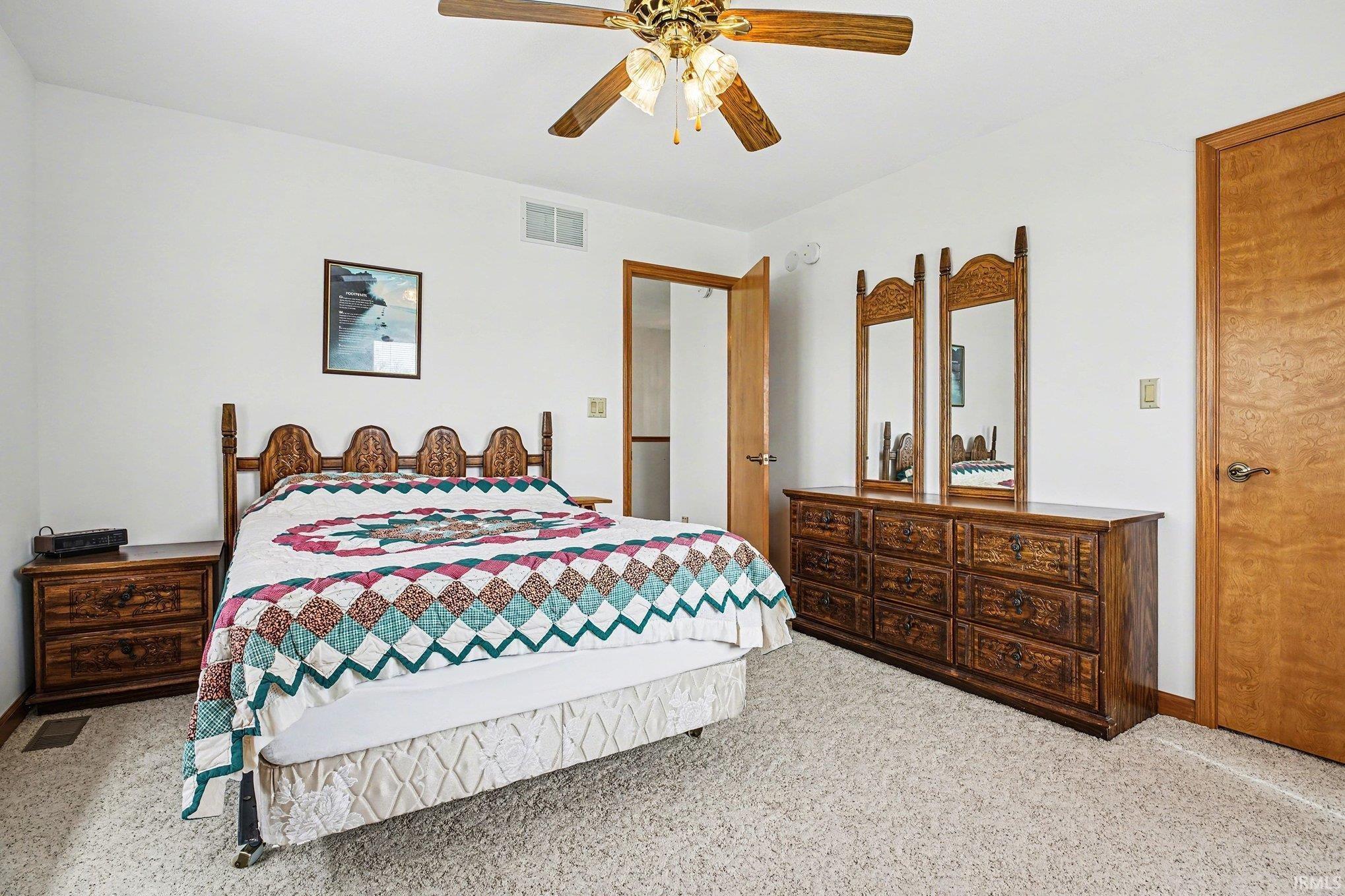 Bedroom with ceiling fan and light colored carpet