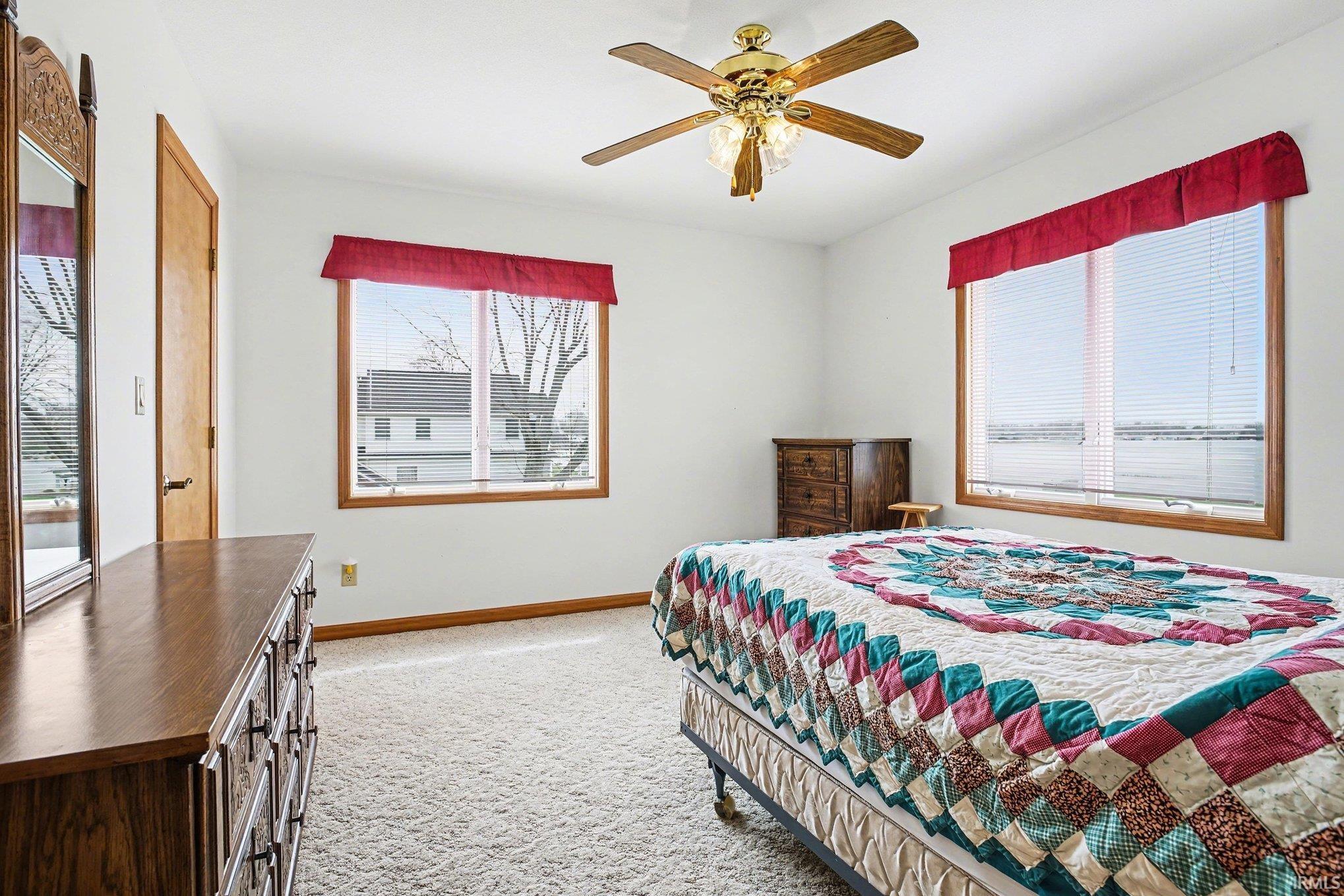 Bedroom featuring light carpet, a ceiling fan, and access to outside
