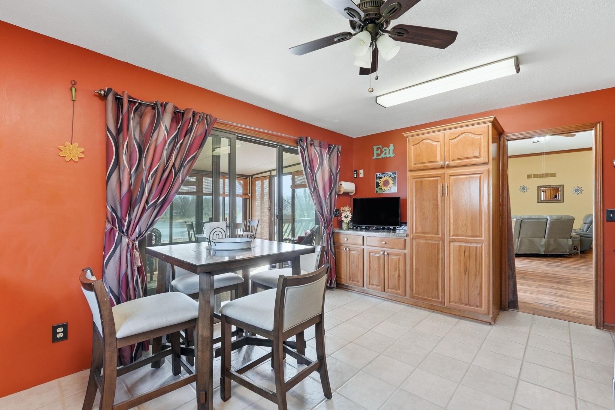 Dining area with ceiling fan and light tile patterned flooring