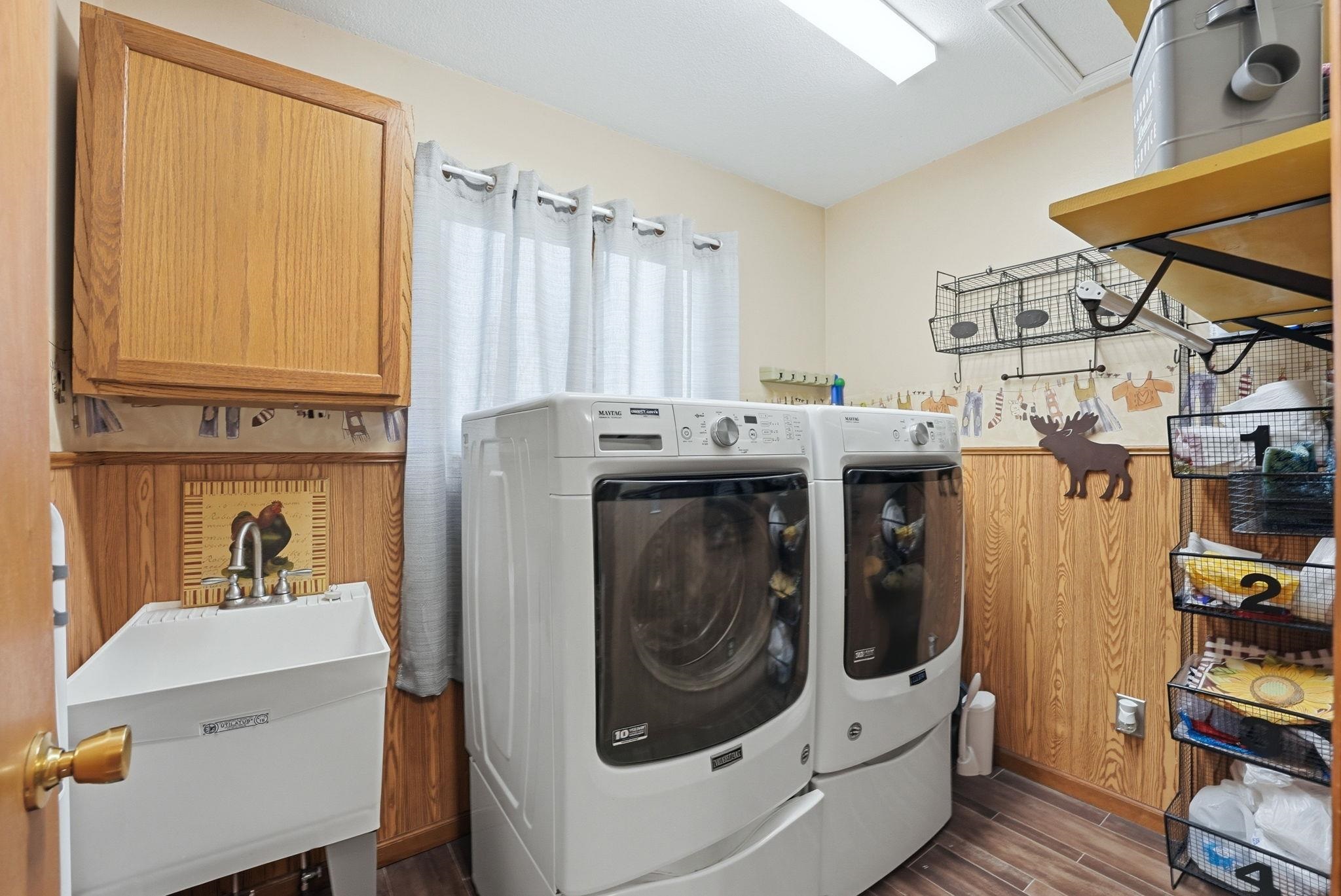 Laundry room with wood finish floors and washing machine and clothes dryer