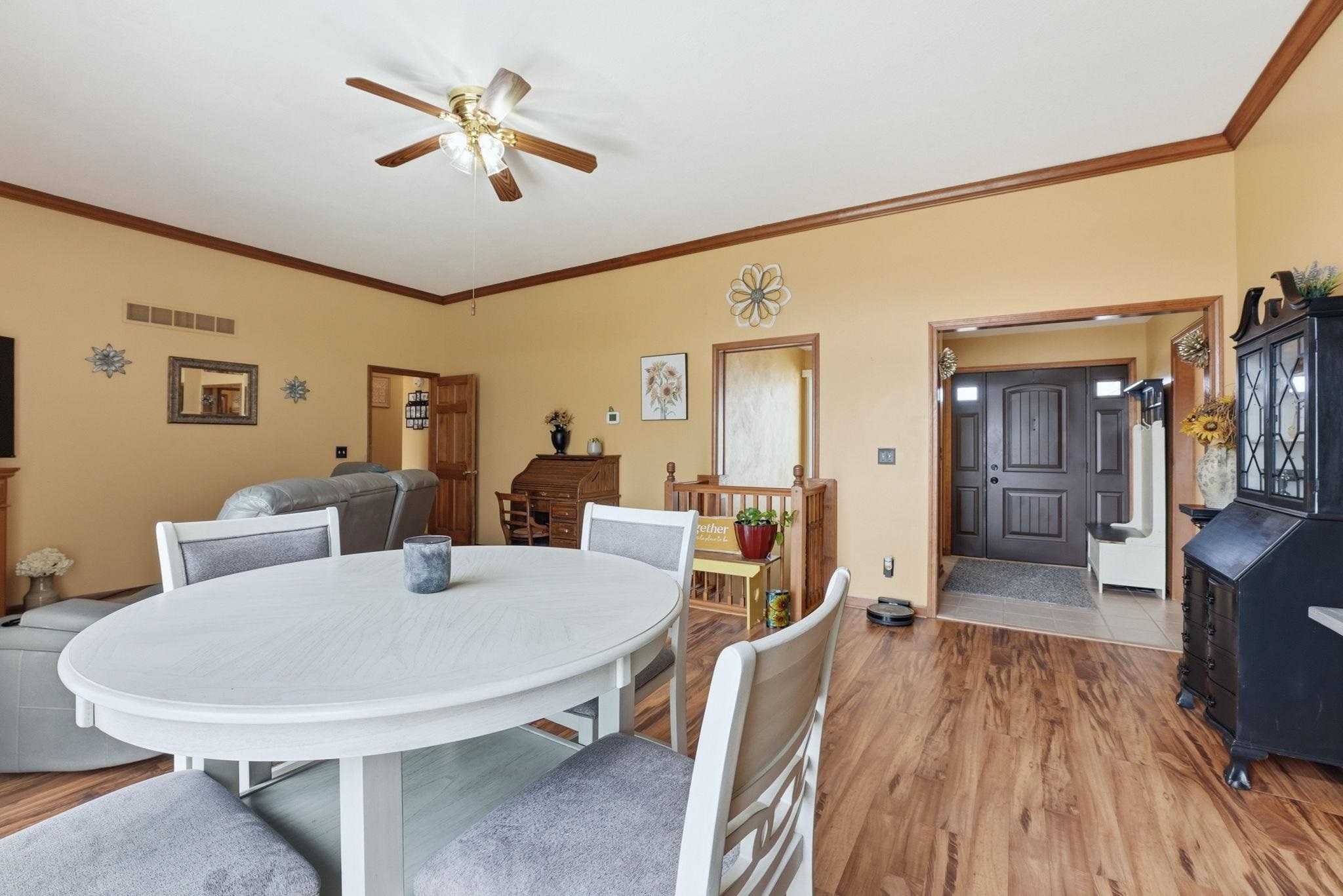 Dining space featuring light wood-style floors, a ceiling fan, and ornamental molding