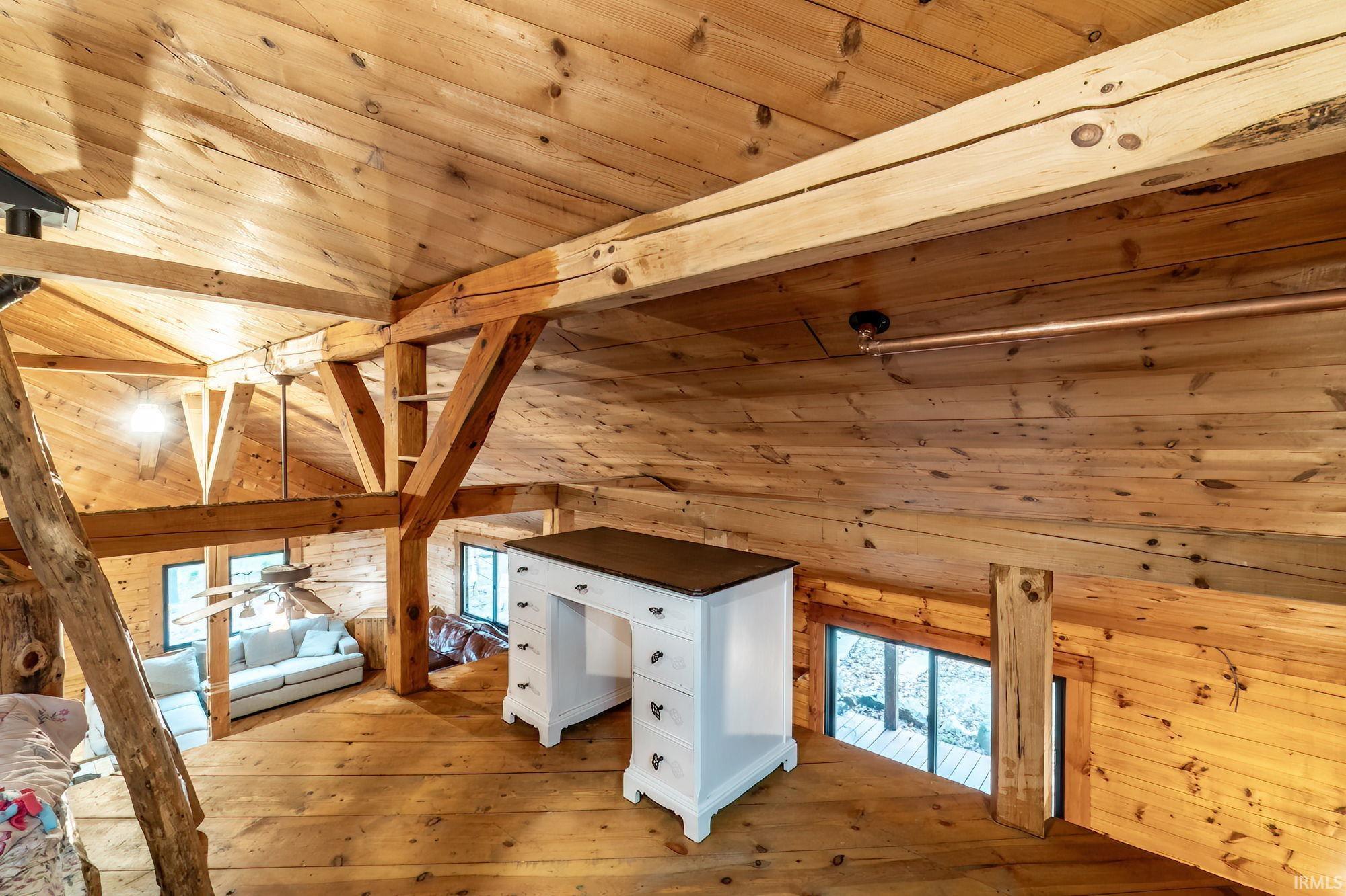 Additional living space featuring vaulted ceiling with beams, wood ceiling, wooden walls, and wood-type flooring