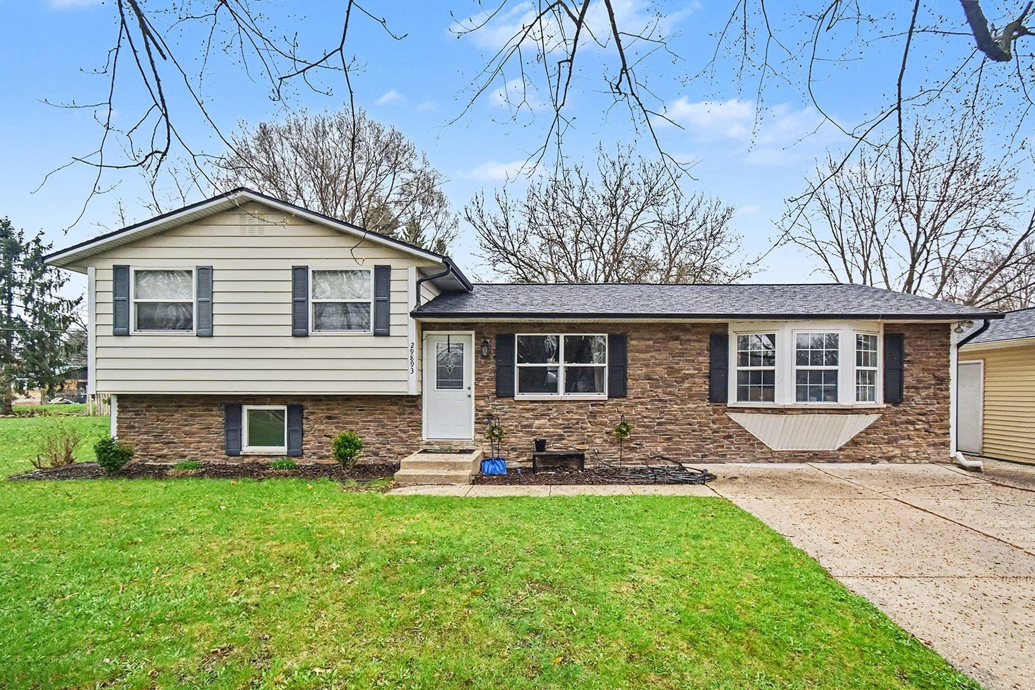 Split level home featuring a front yard and entry steps