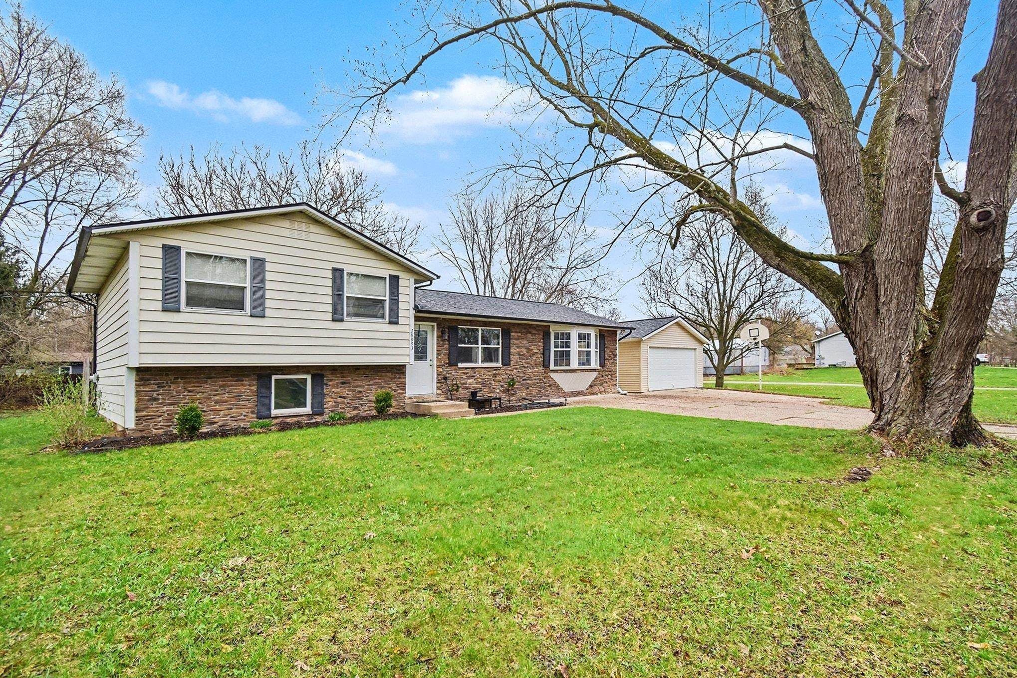Tri-level home with a front lawn, a garage, and concrete driveway
