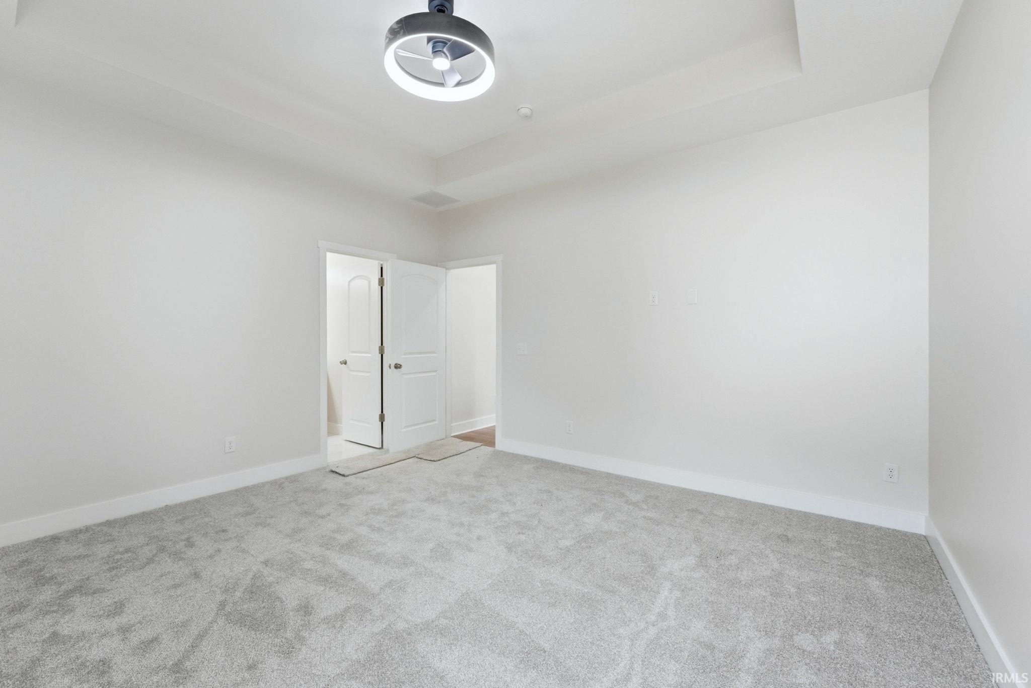 Unfurnished bedroom featuring baseboards and light carpet
