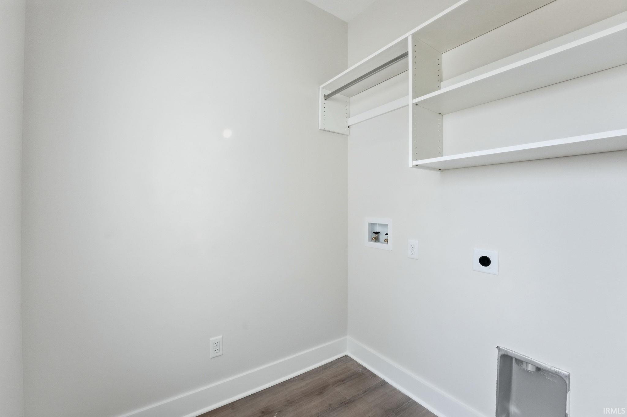 Laundry area featuring dark wood finished floors, washer hookup, and electric dryer hookup