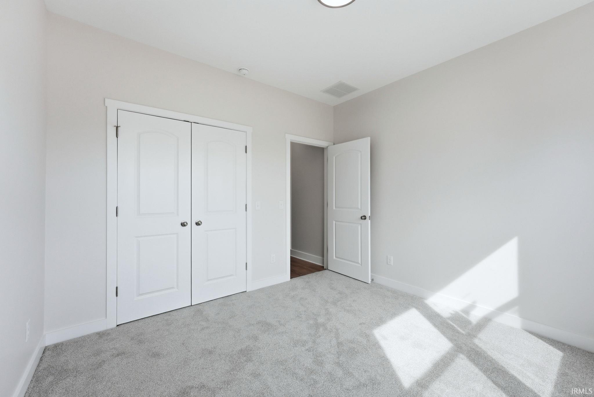 Unfurnished bedroom featuring carpet flooring and a closet