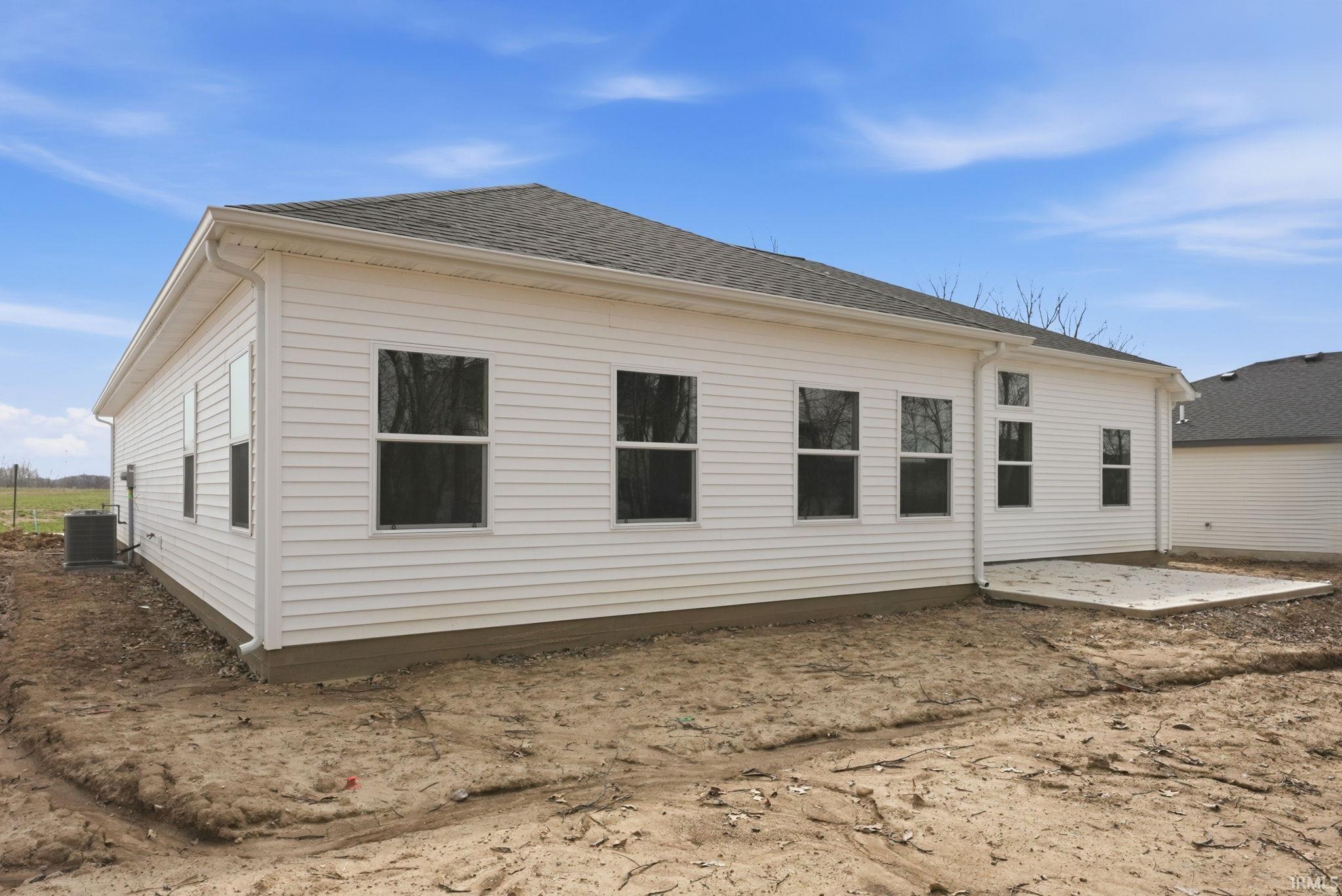 Rear view of property with a patio area and roof with shingles