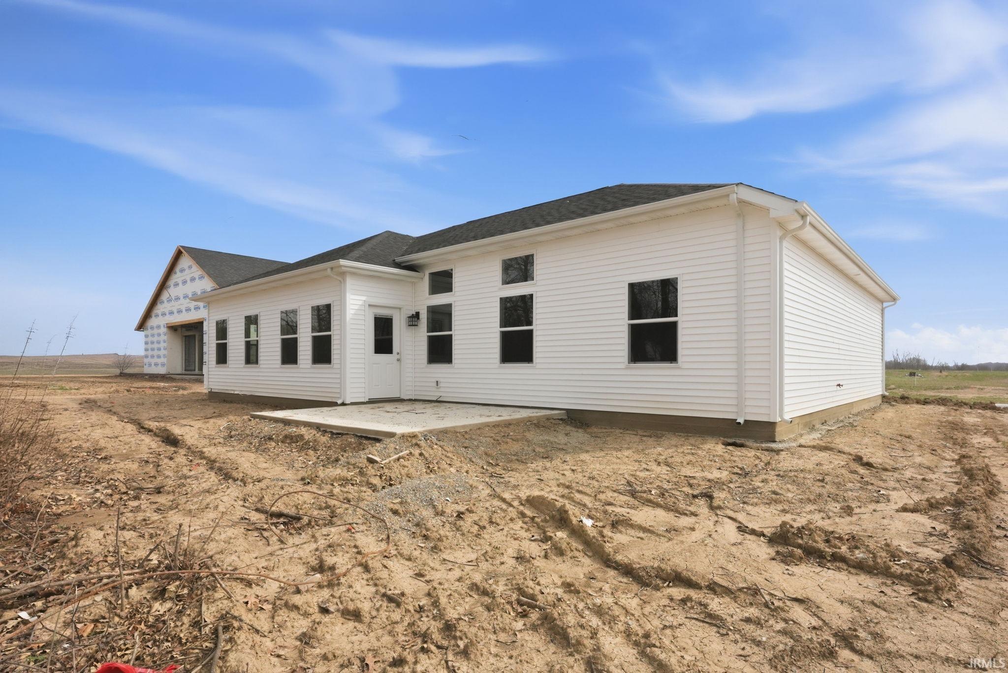 Rear view of house with a patio and roof with shingles
