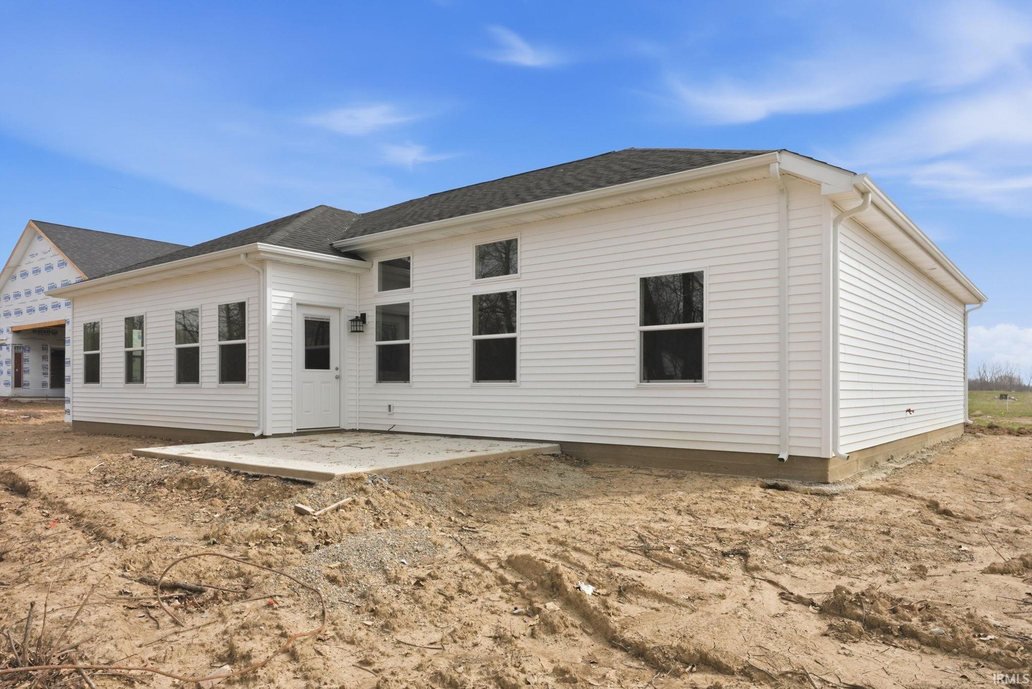 Back of property with a patio and roof with shingles