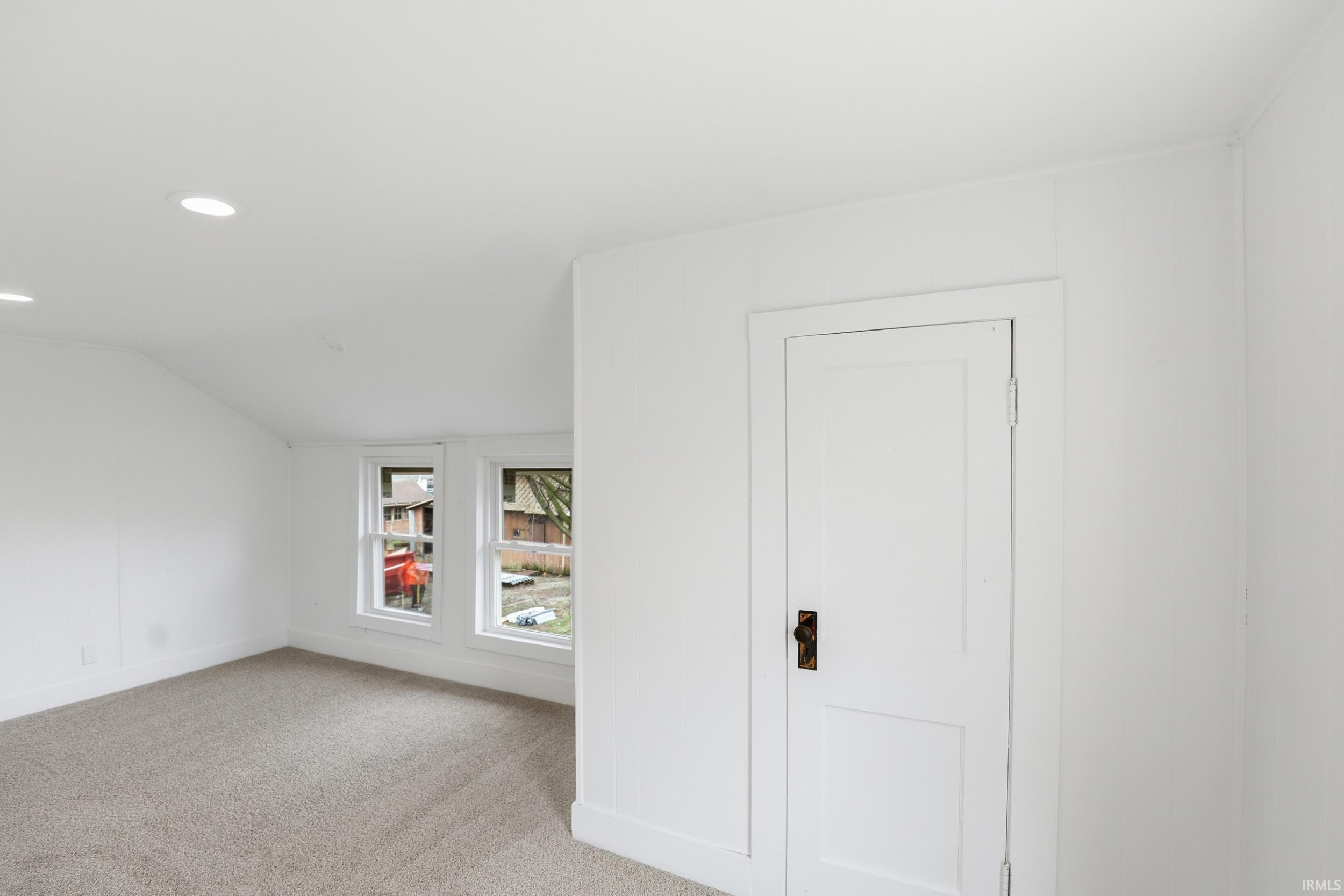 Unfurnished room featuring lofted ceiling, light carpet, and recessed lighting