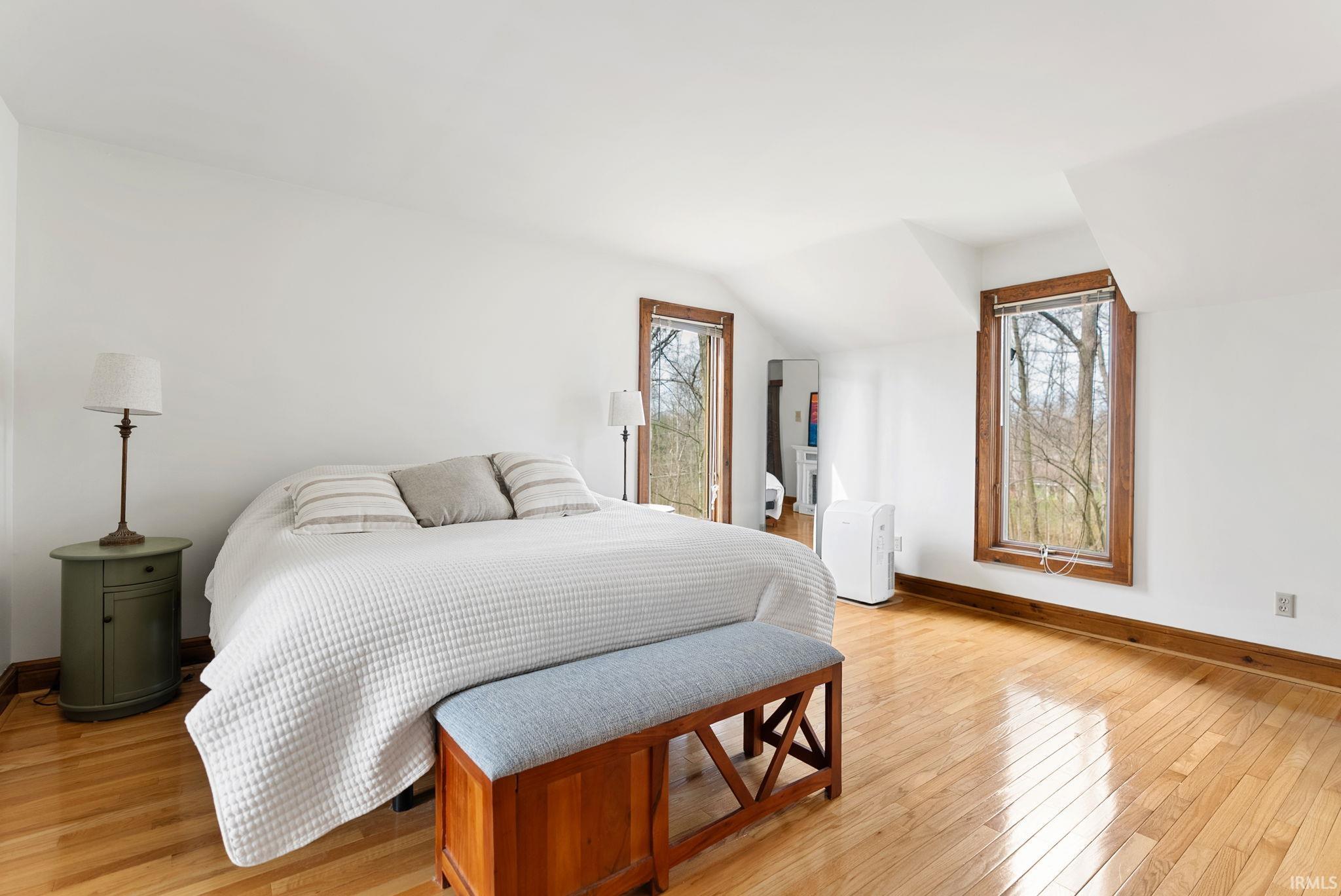 Bedroom featuring light wood finished floors and vaulted ceiling
