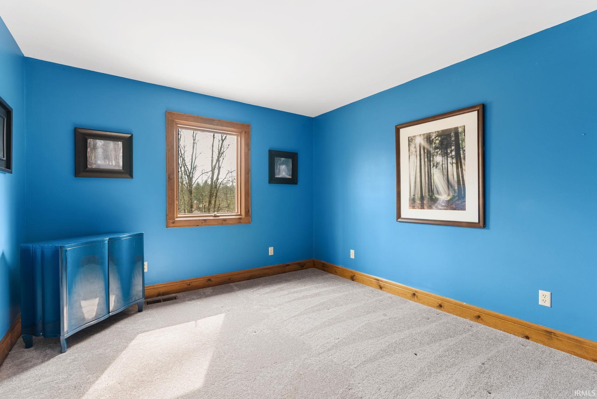 Unfurnished room with baseboards and light carpet