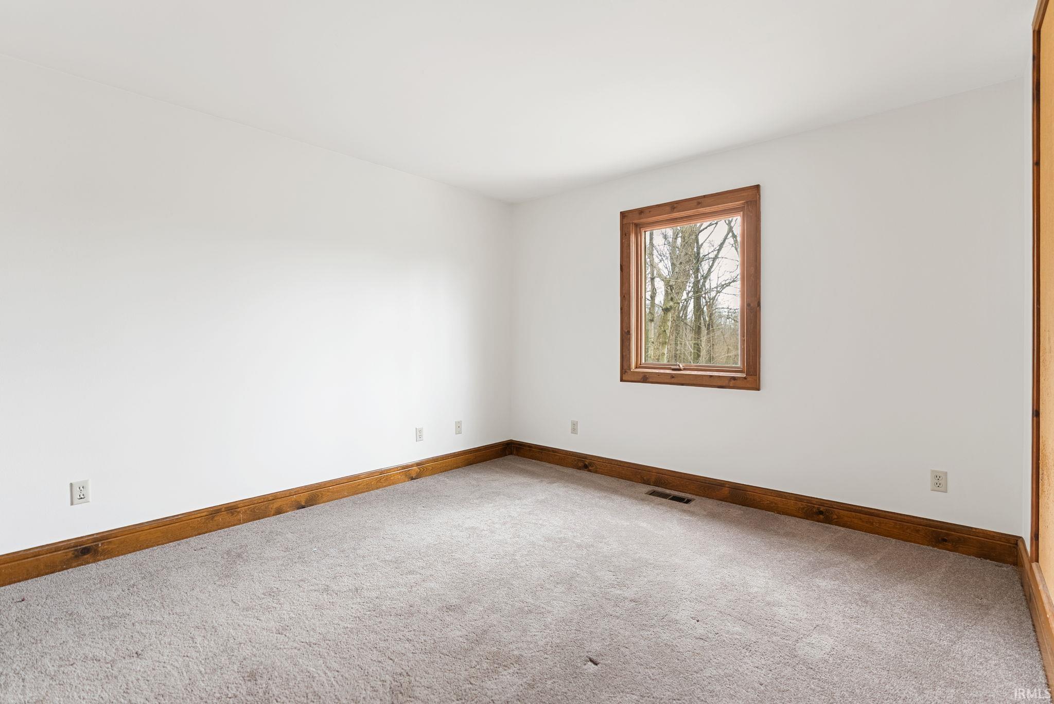Carpeted empty room featuring baseboards