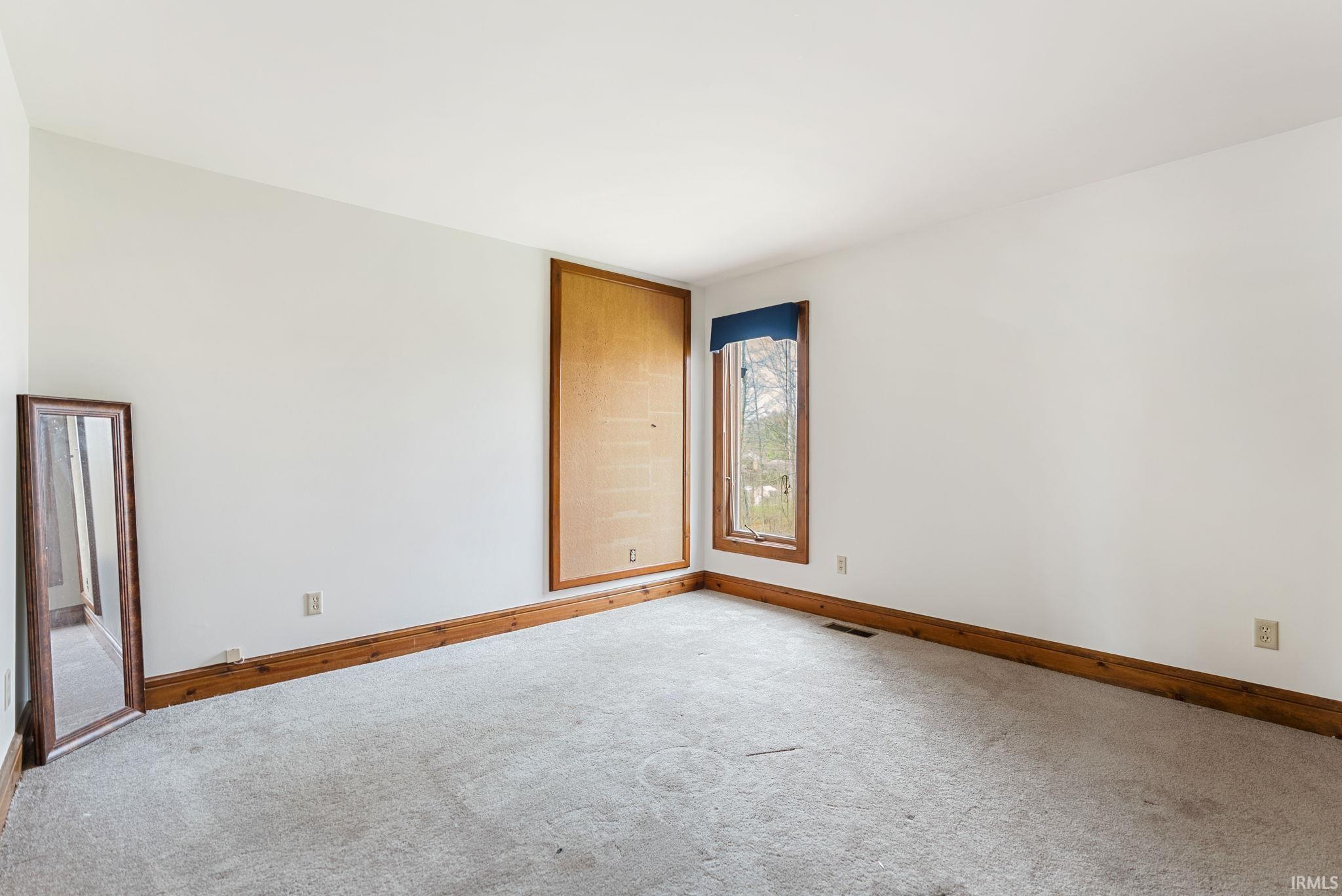 Unfurnished room with baseboards and carpet