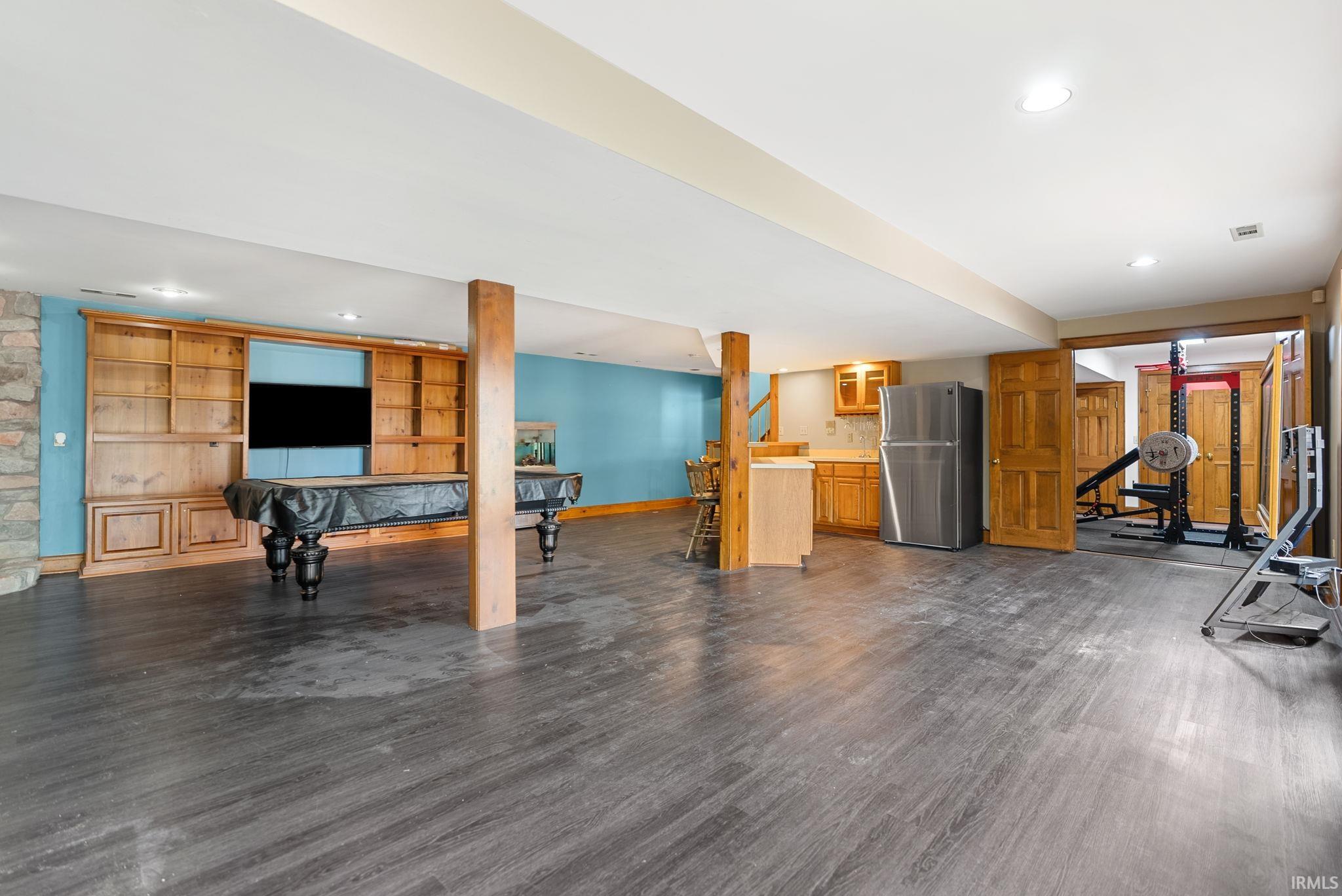 Workout room with dark wood-style flooring, recessed lighting, and billiards table