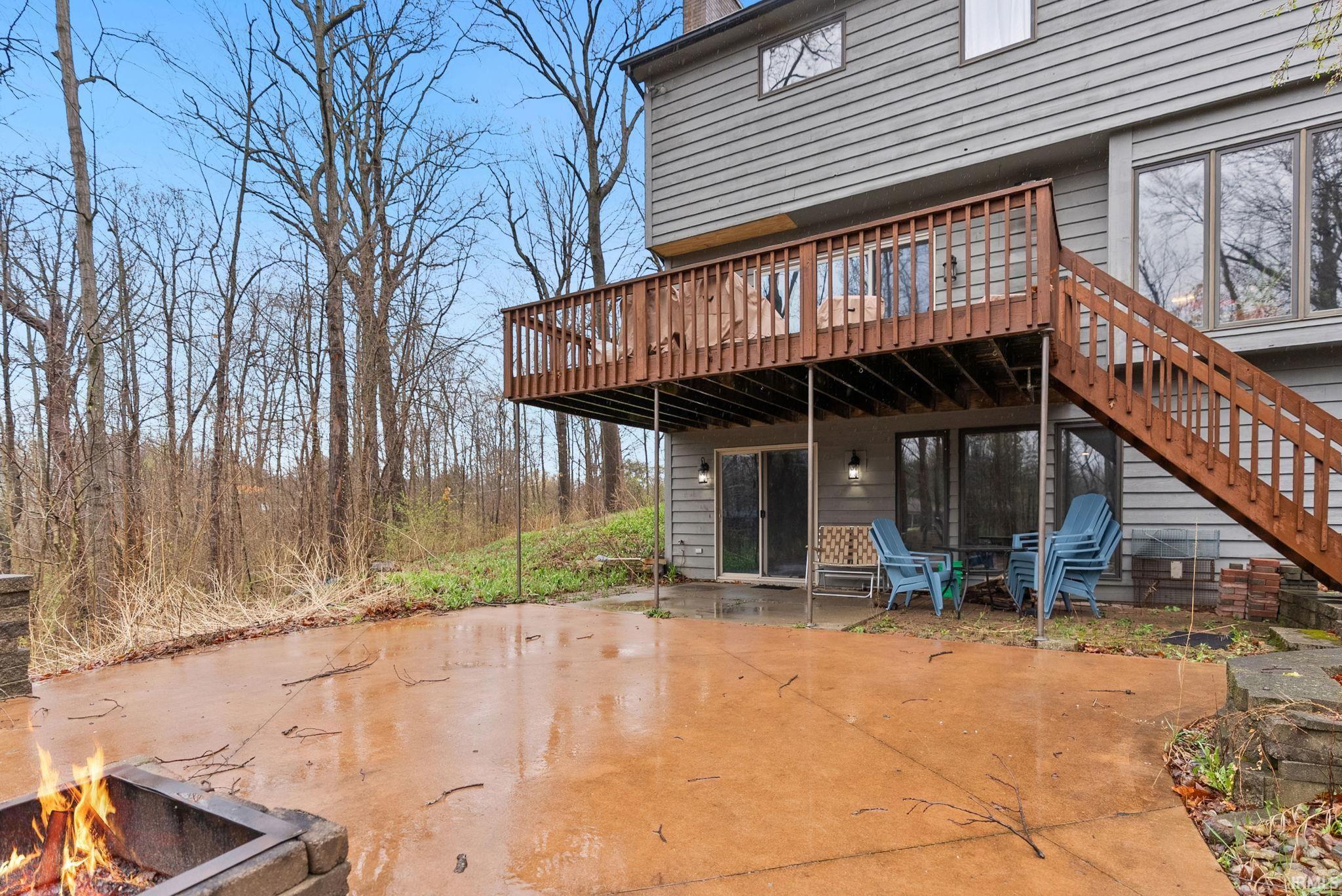 Rear view of property featuring a fire pit, a deck, and a patio area