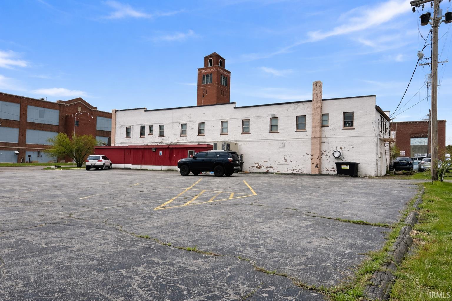 View of building exterior with uncovered parking