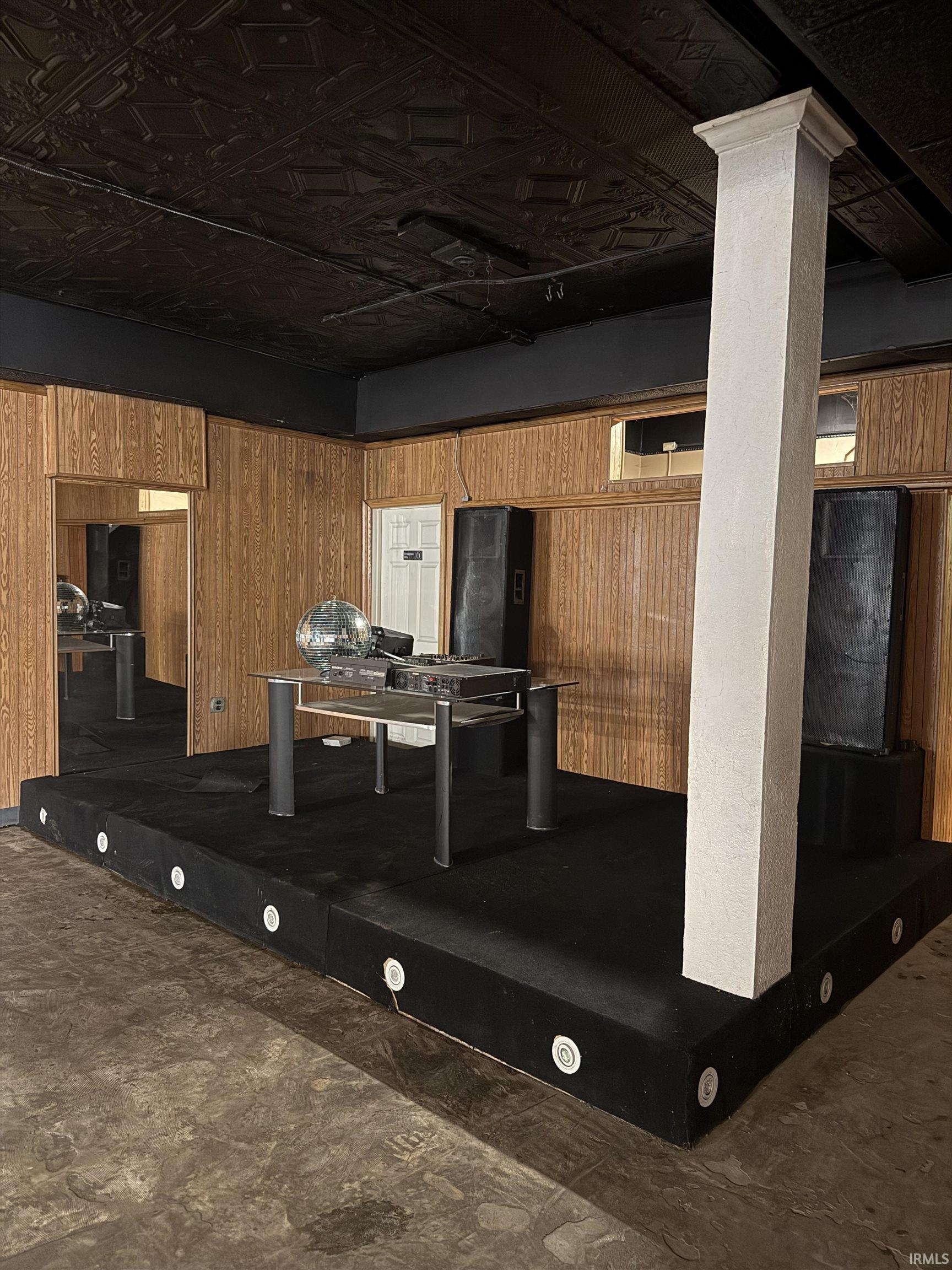 Basement featuring an ornate ceiling and wooden walls