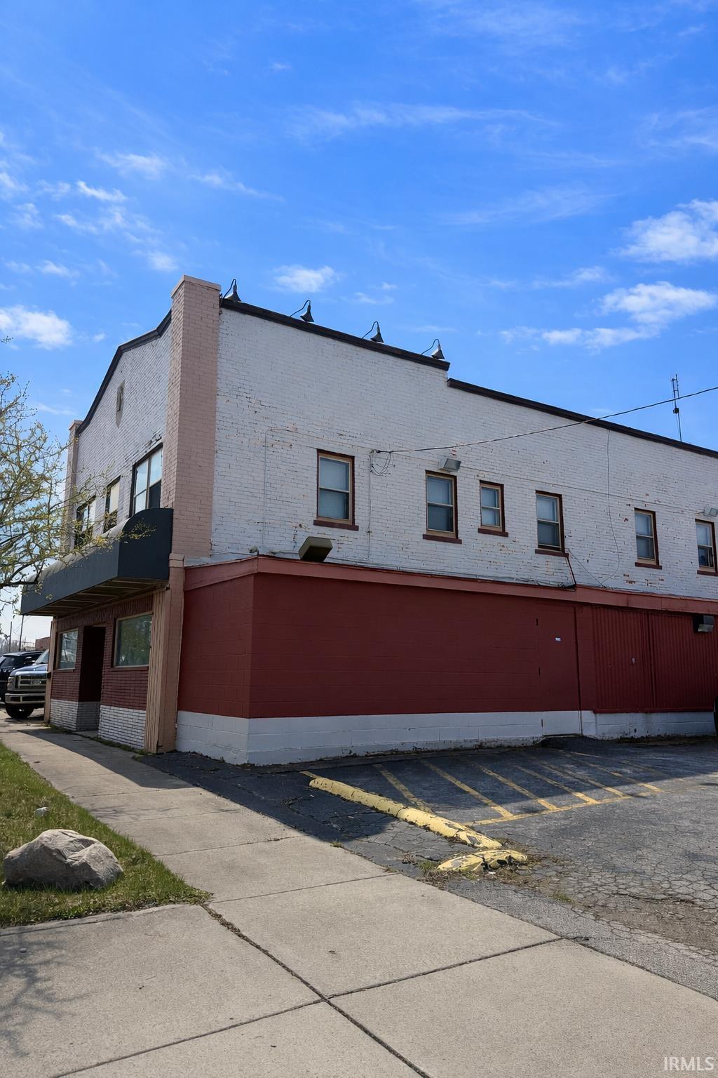 View of side of home featuring uncovered parking and brick siding