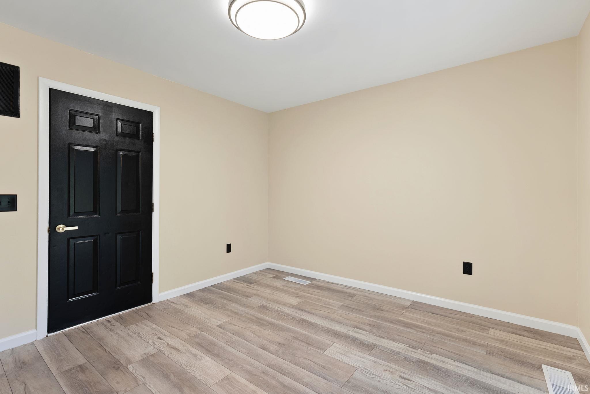 Spare room featuring light wood-style floors and baseboards