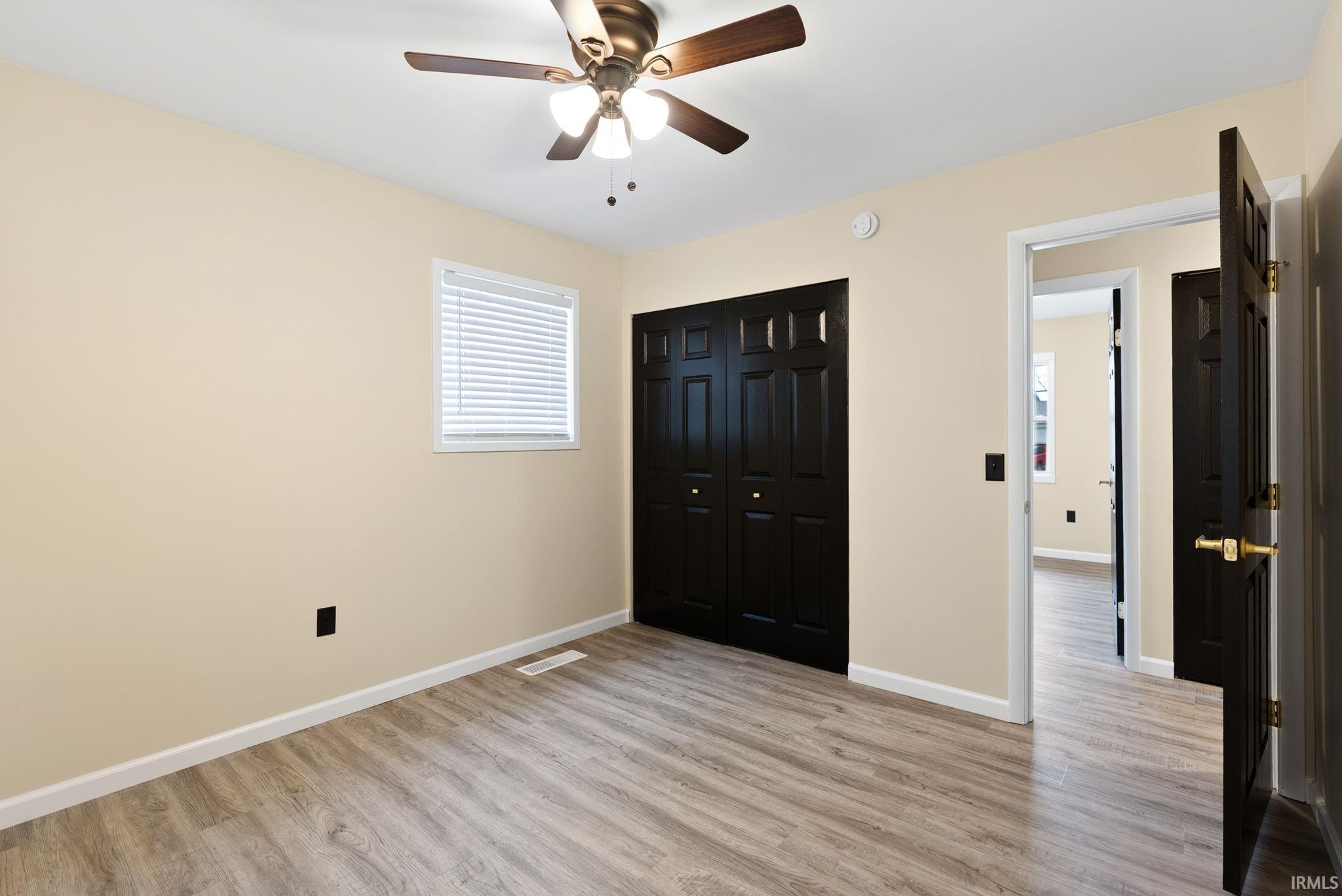 Unfurnished bedroom with light wood-type flooring, a closet, and ceiling fan