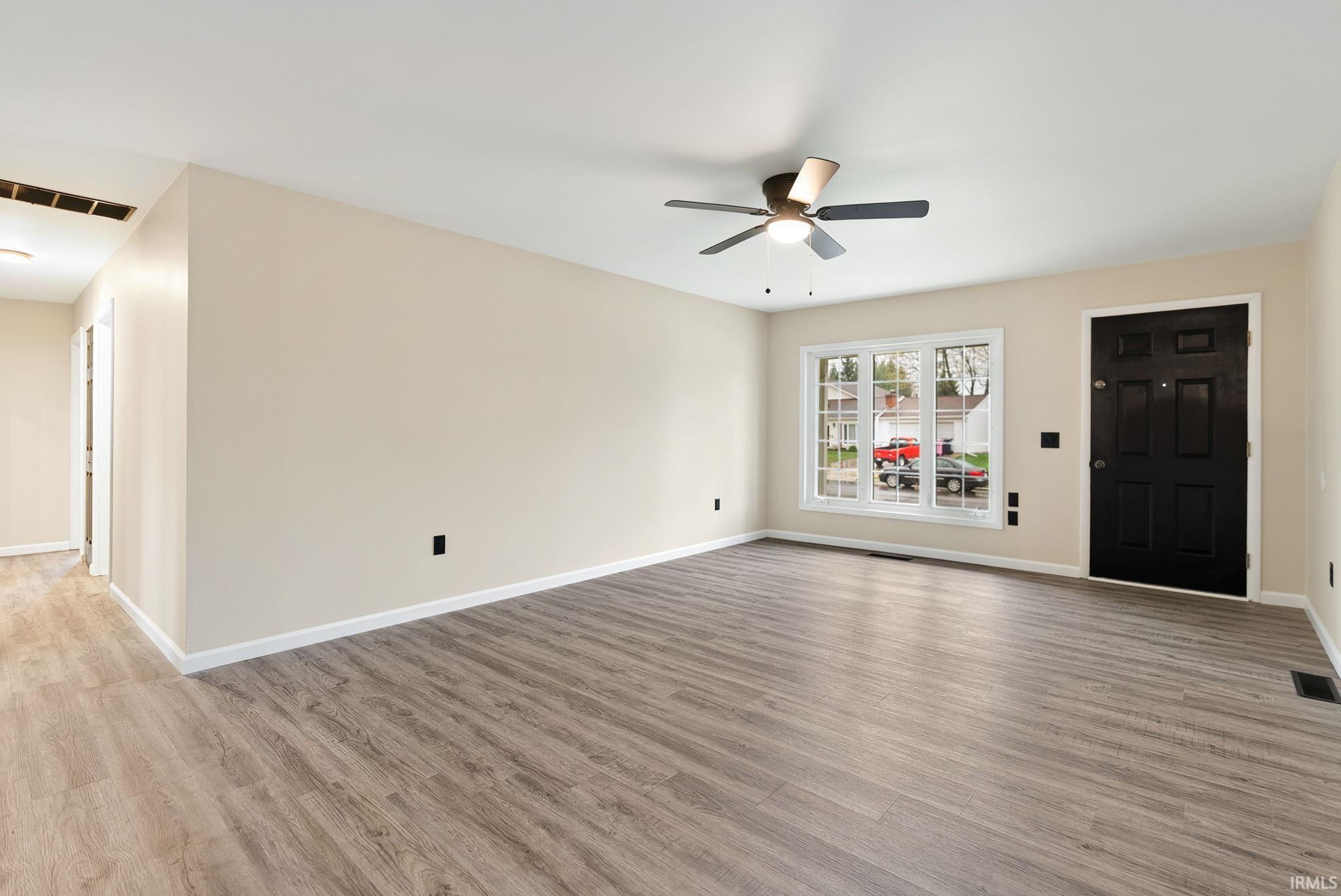 Unfurnished living room featuring light wood-style flooring and a ceiling fan