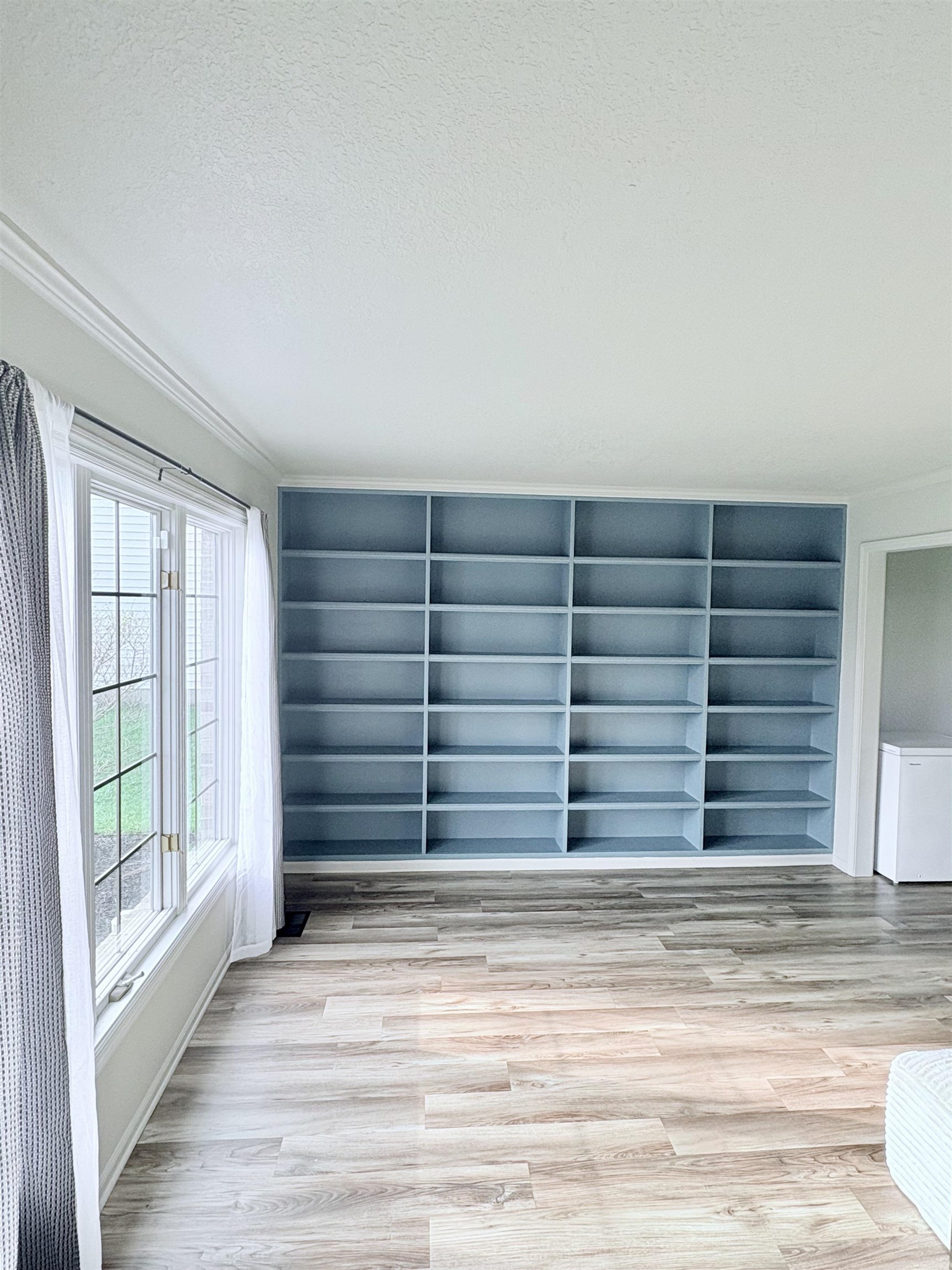 Detailed view of a textured ceiling, wood finished floors, and white refrigerator