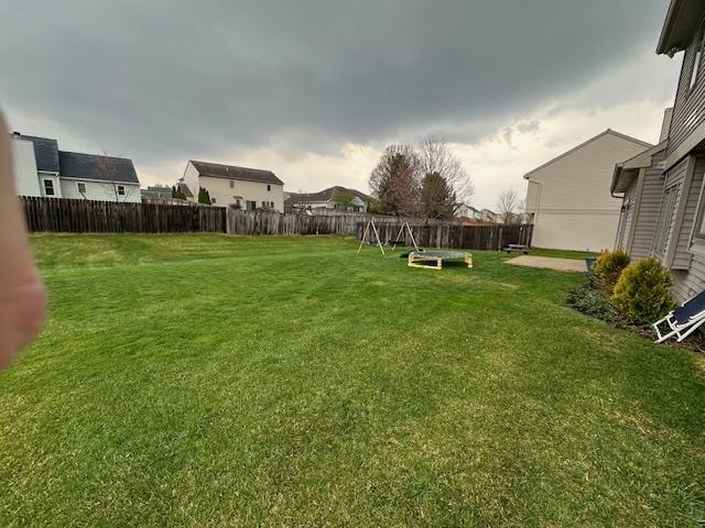 Fenced backyard featuring a playground