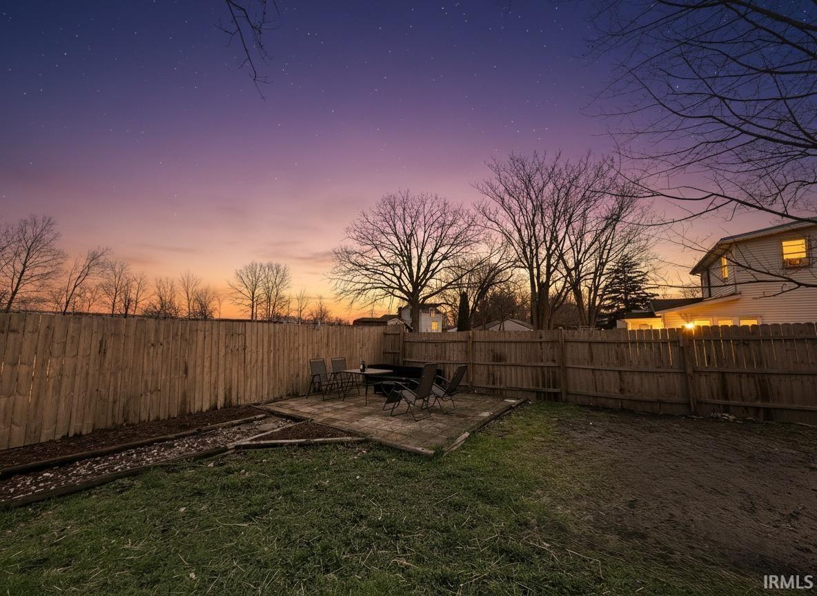 Yard at dusk featuring a patio area and a fenced backyard