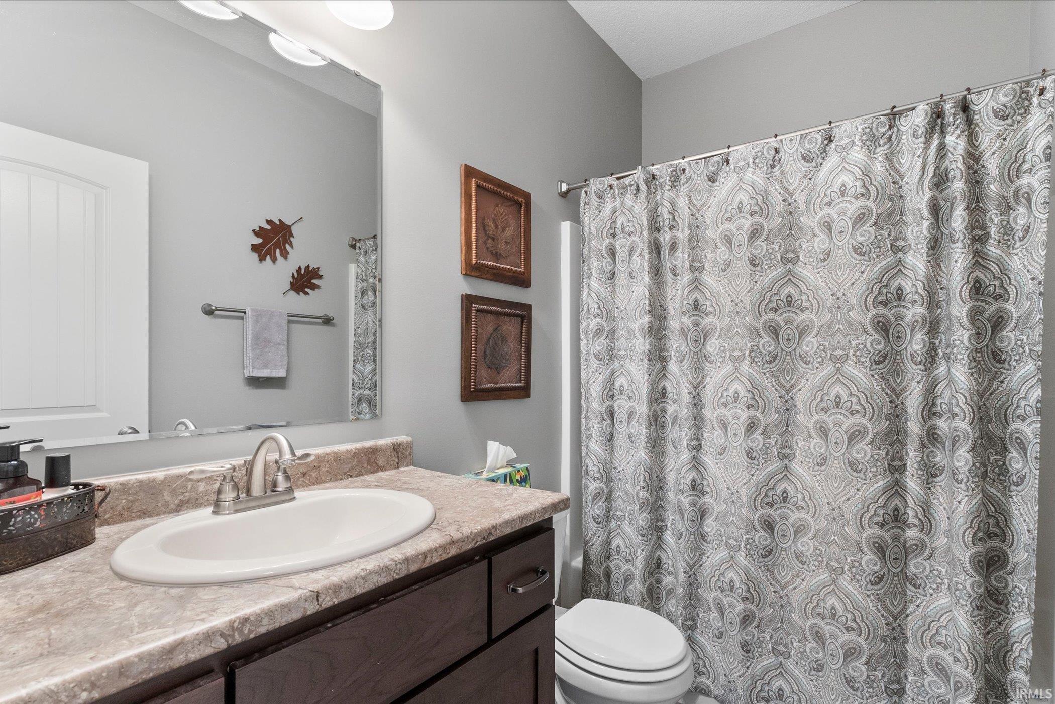 Bathroom with vanity and curtained shower