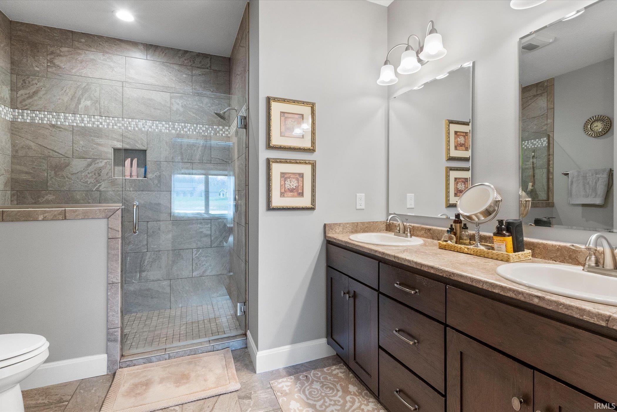 Bathroom with double vanity and a shower stall