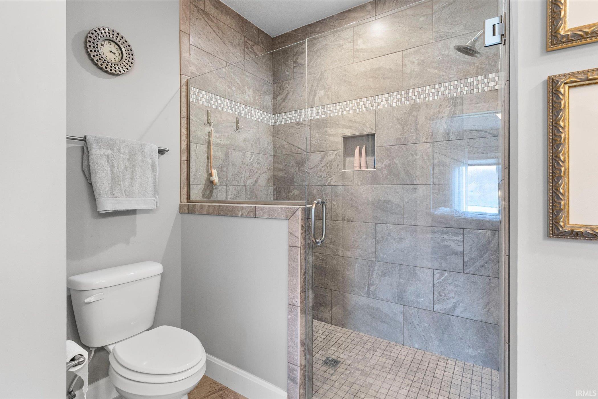 Full bathroom featuring toilet and a shower stall