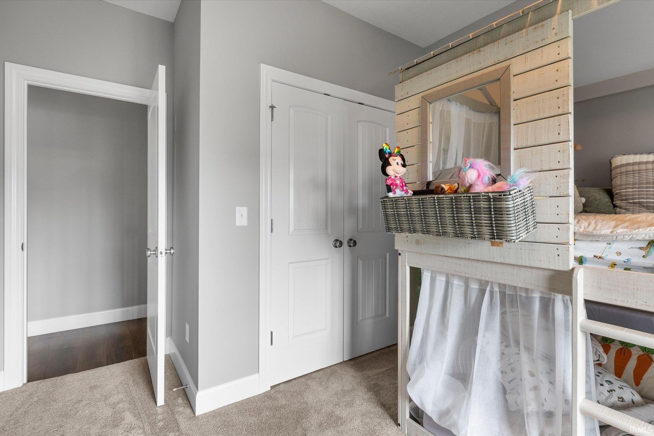 Bedroom featuring light colored carpet and a closet