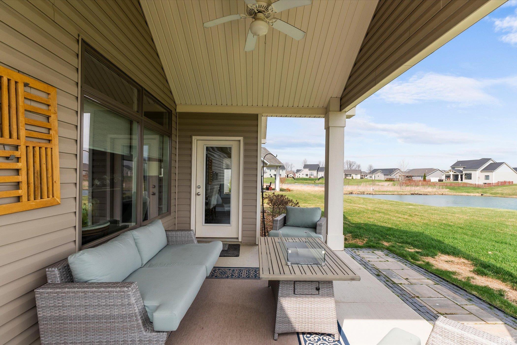 View of patio / terrace with a water view, an outdoor lounge area, a ceiling fan, and a residential view