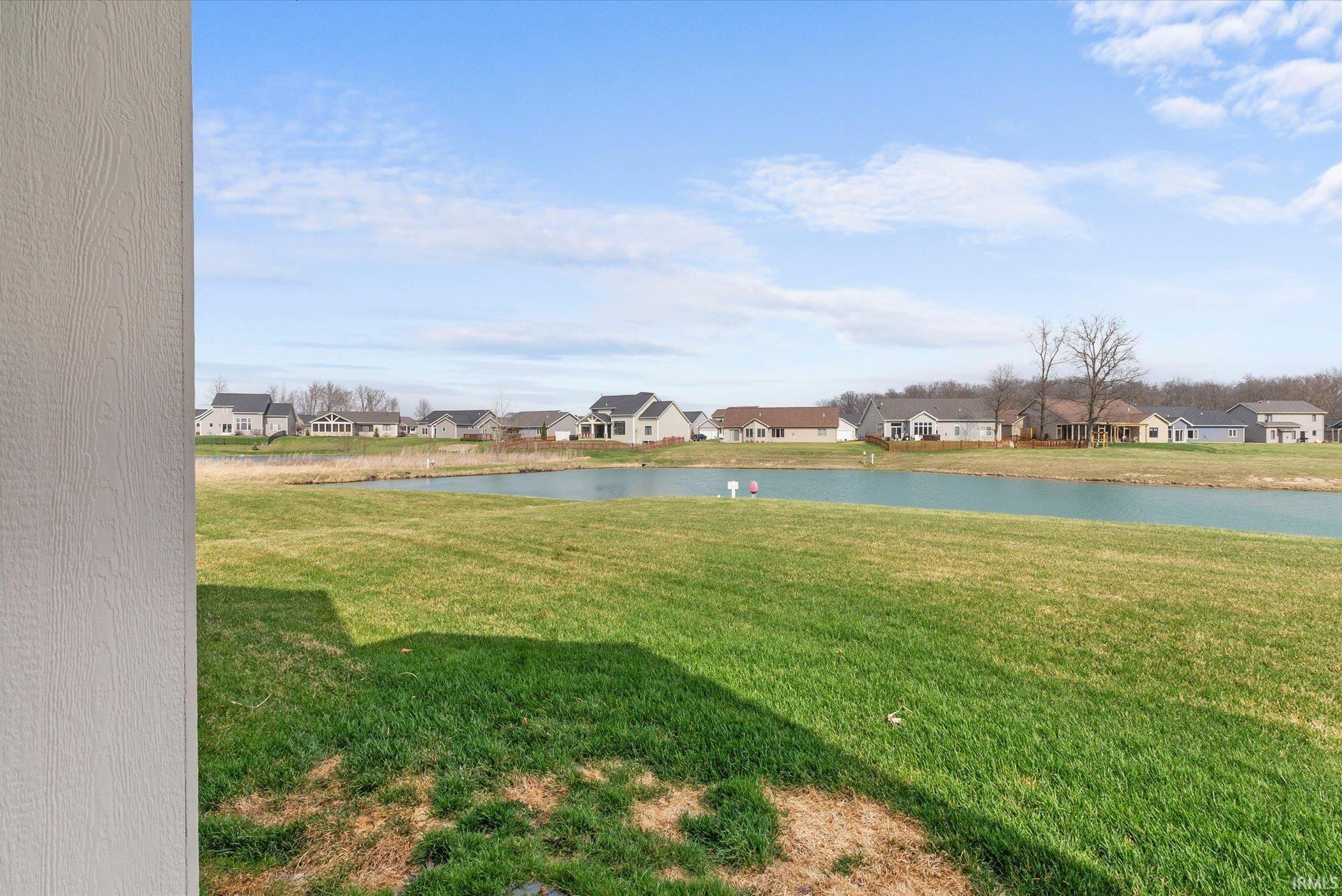 View of grassy yard featuring a water view and a residential view