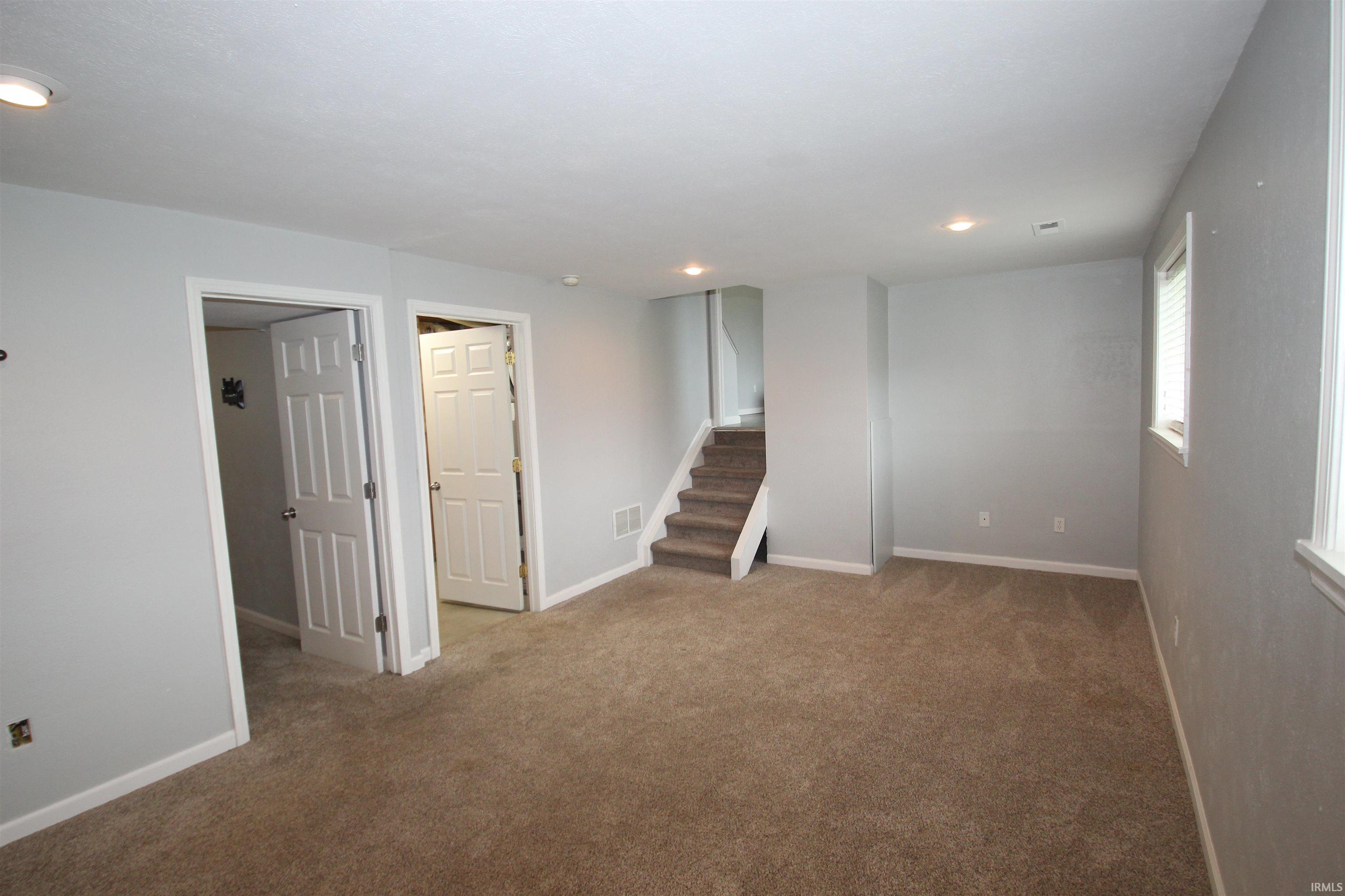 Empty room with carpet and recessed lighting