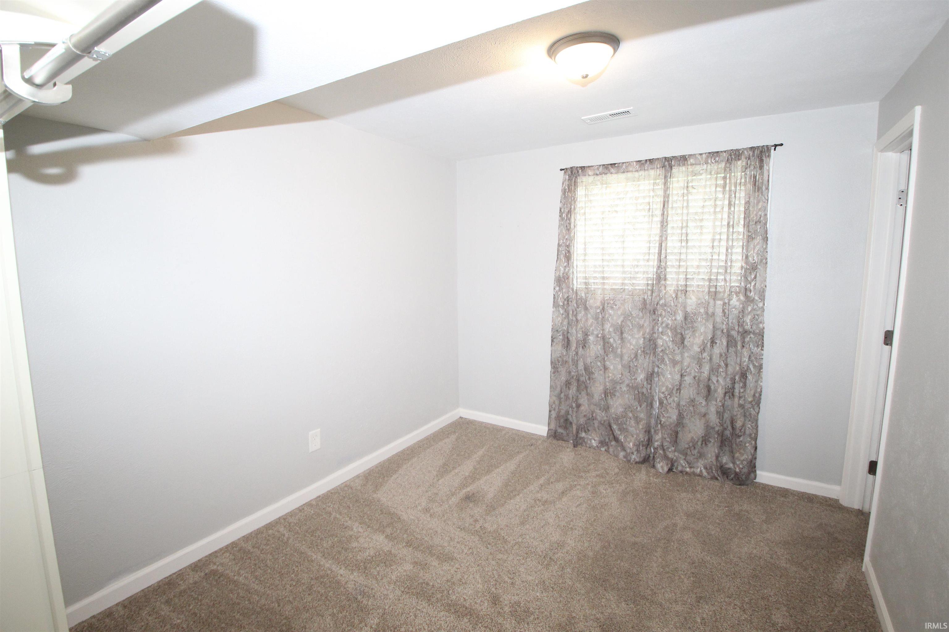 Spare room with carpet floors and baseboards