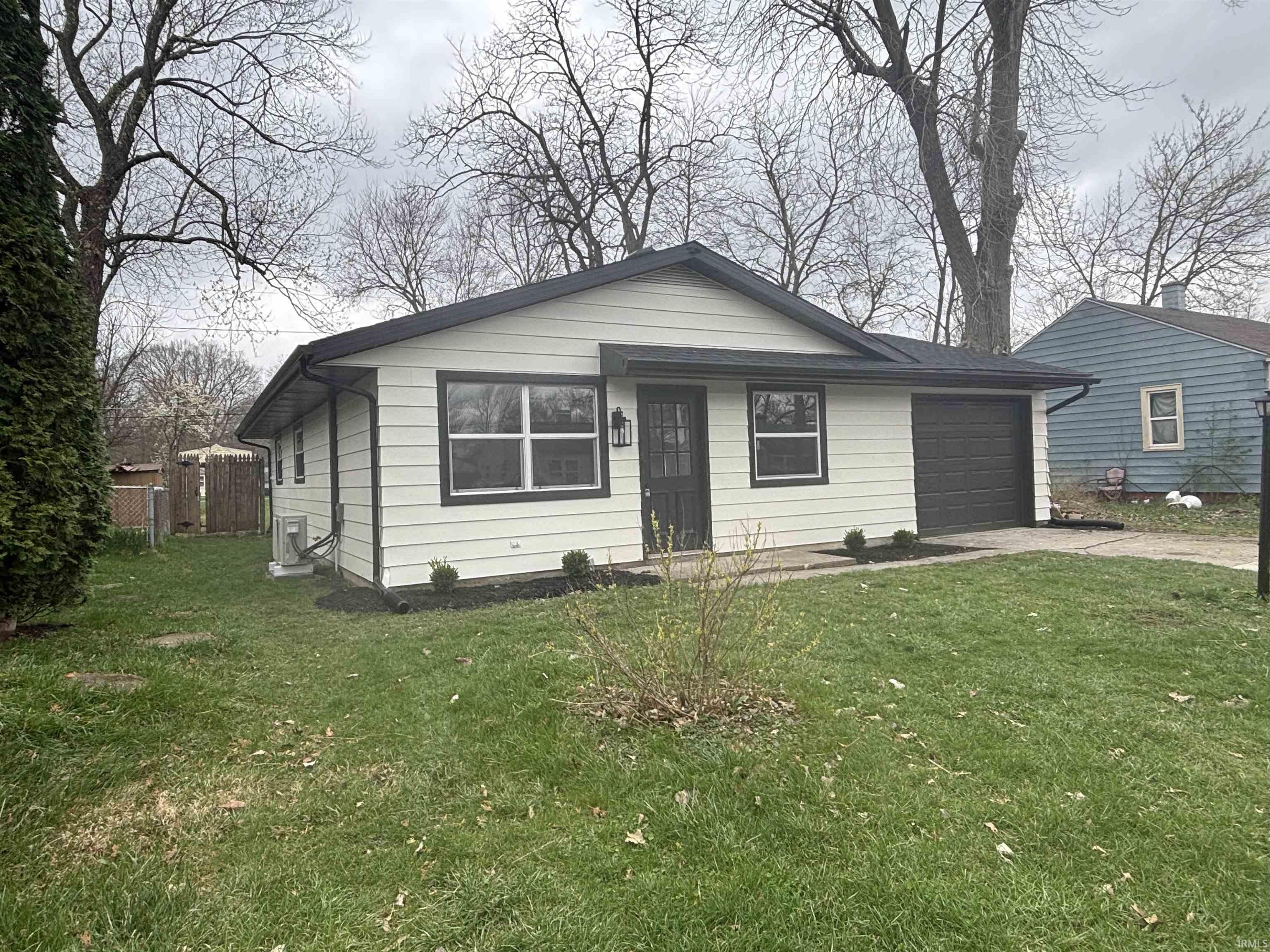 View of front of home featuring concrete driveway and an attached garage