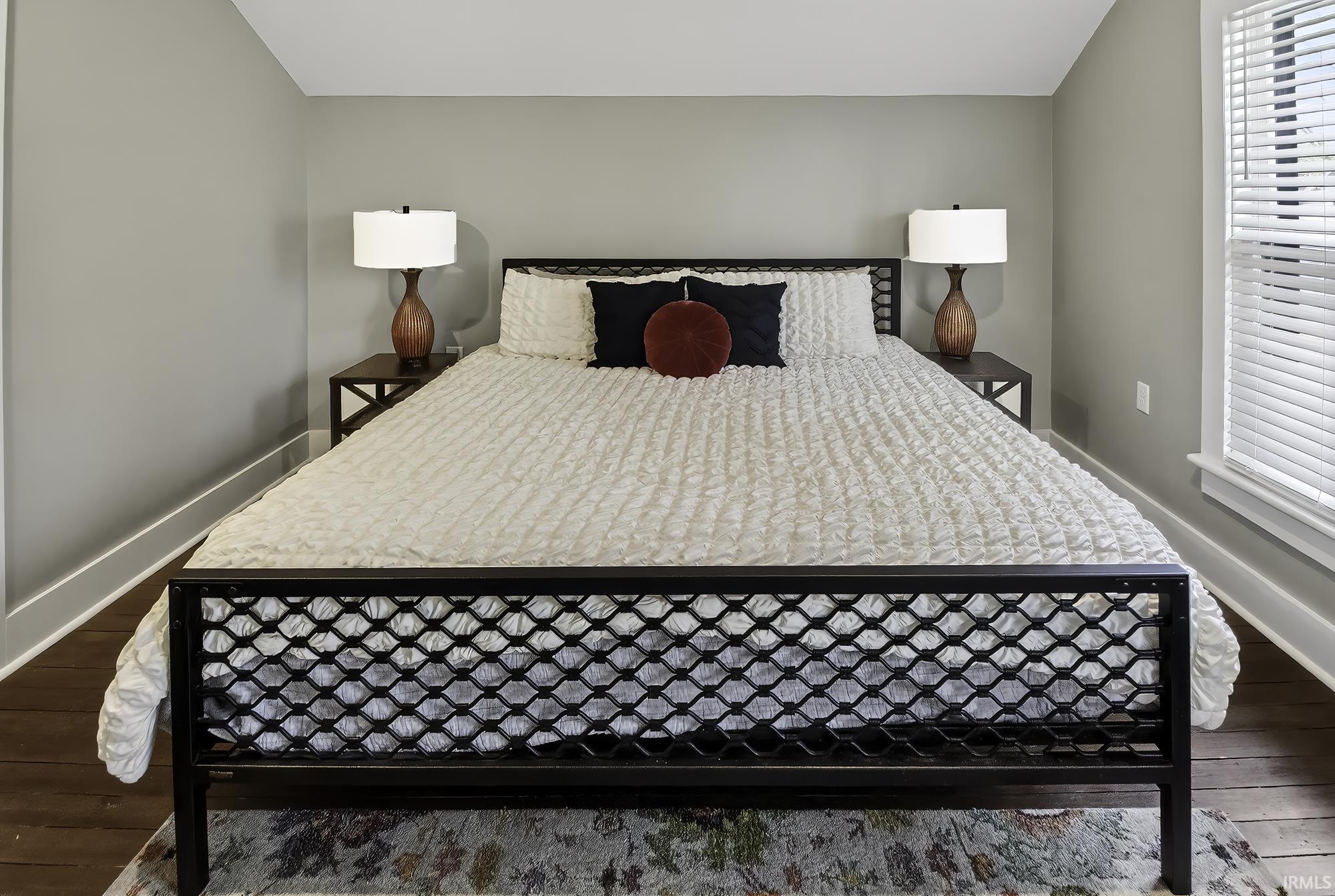 Bedroom with dark wood-style flooring and lofted ceiling