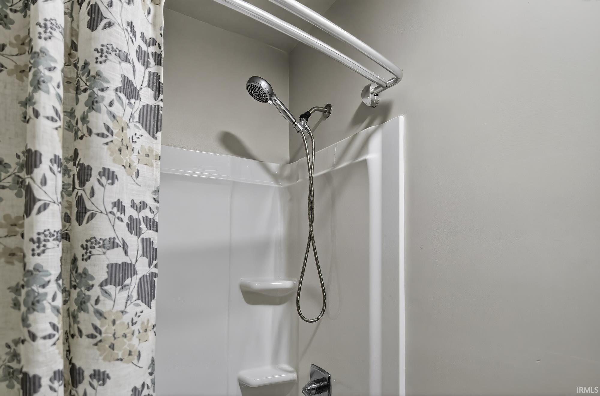 Bathroom view of shower / tub combo with curtain