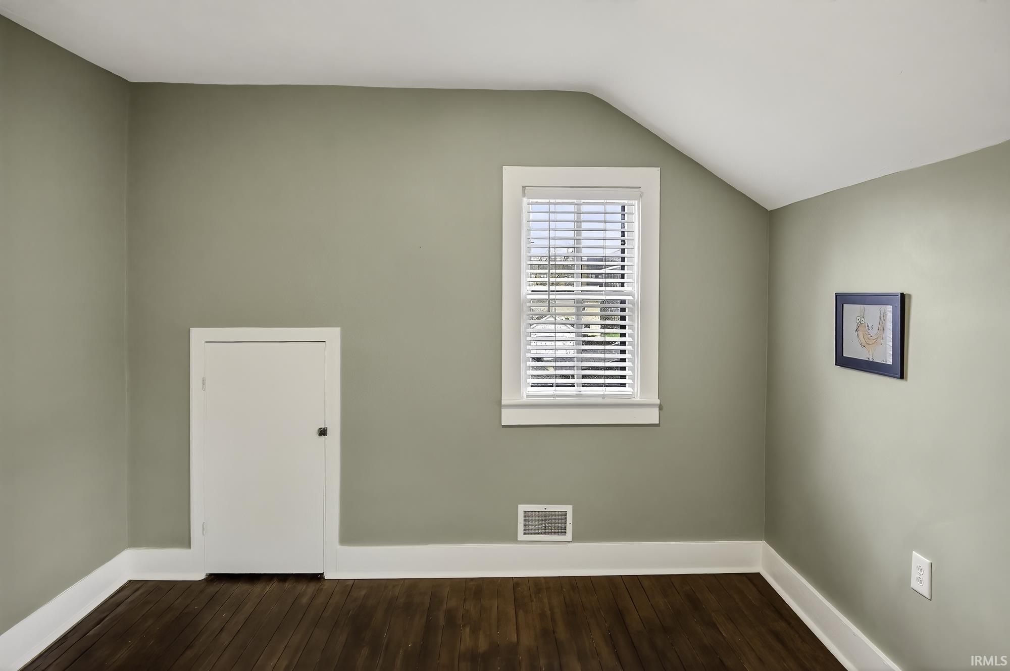 Additional living space featuring lofted ceiling and dark wood-style floors