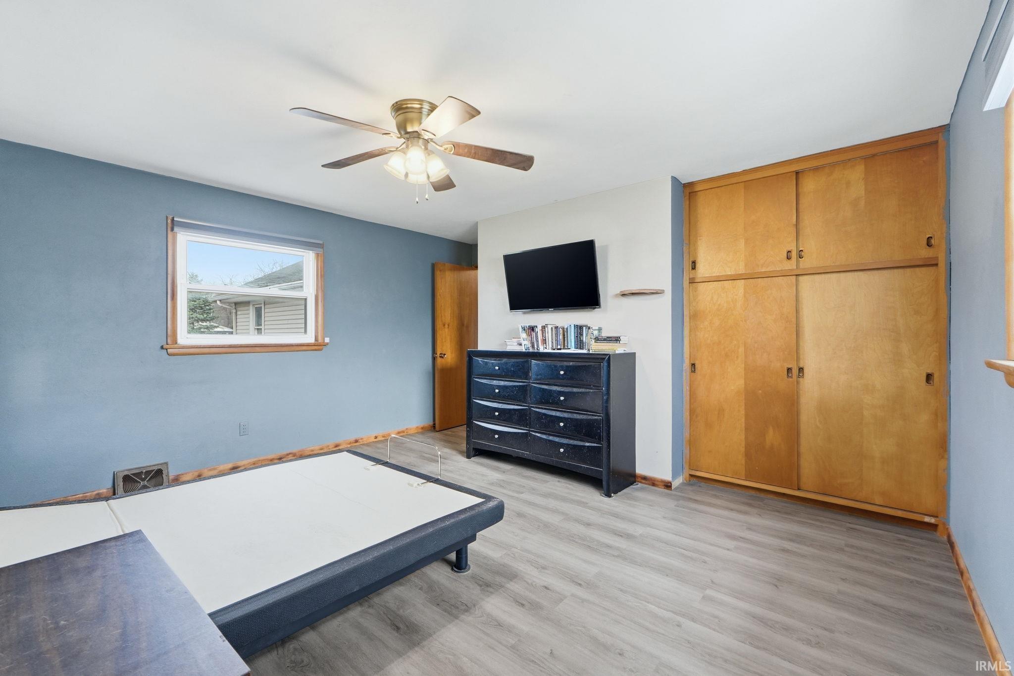 Bedroom featuring ceiling fan, light wood-style floors, and a closet
