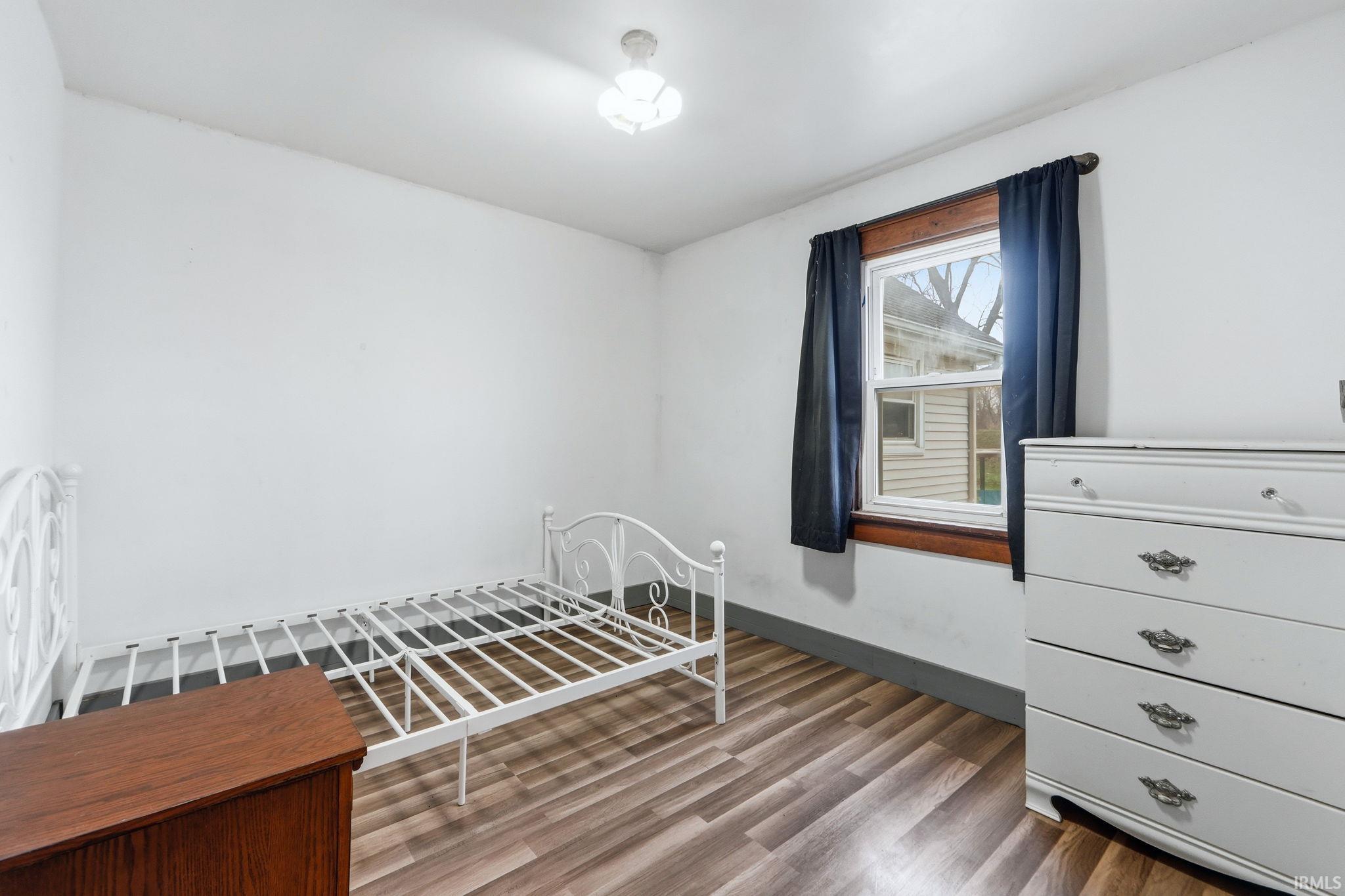Bedroom featuring wood finished floors and baseboards
