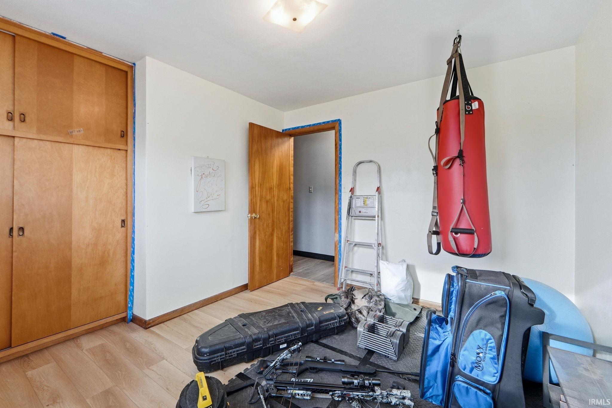 Exercise room featuring light wood-style flooring and baseboards