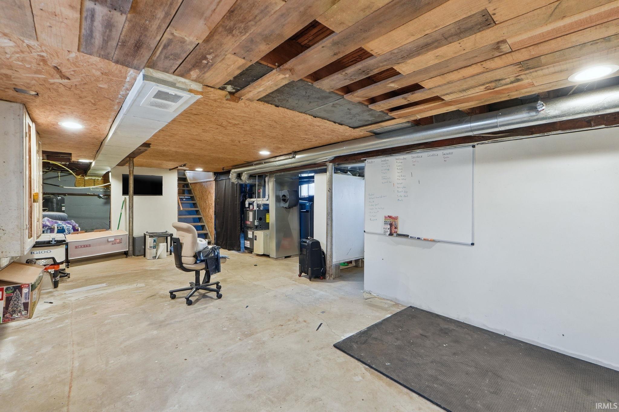 Basement with heating unit, wood ceiling, and recessed lighting