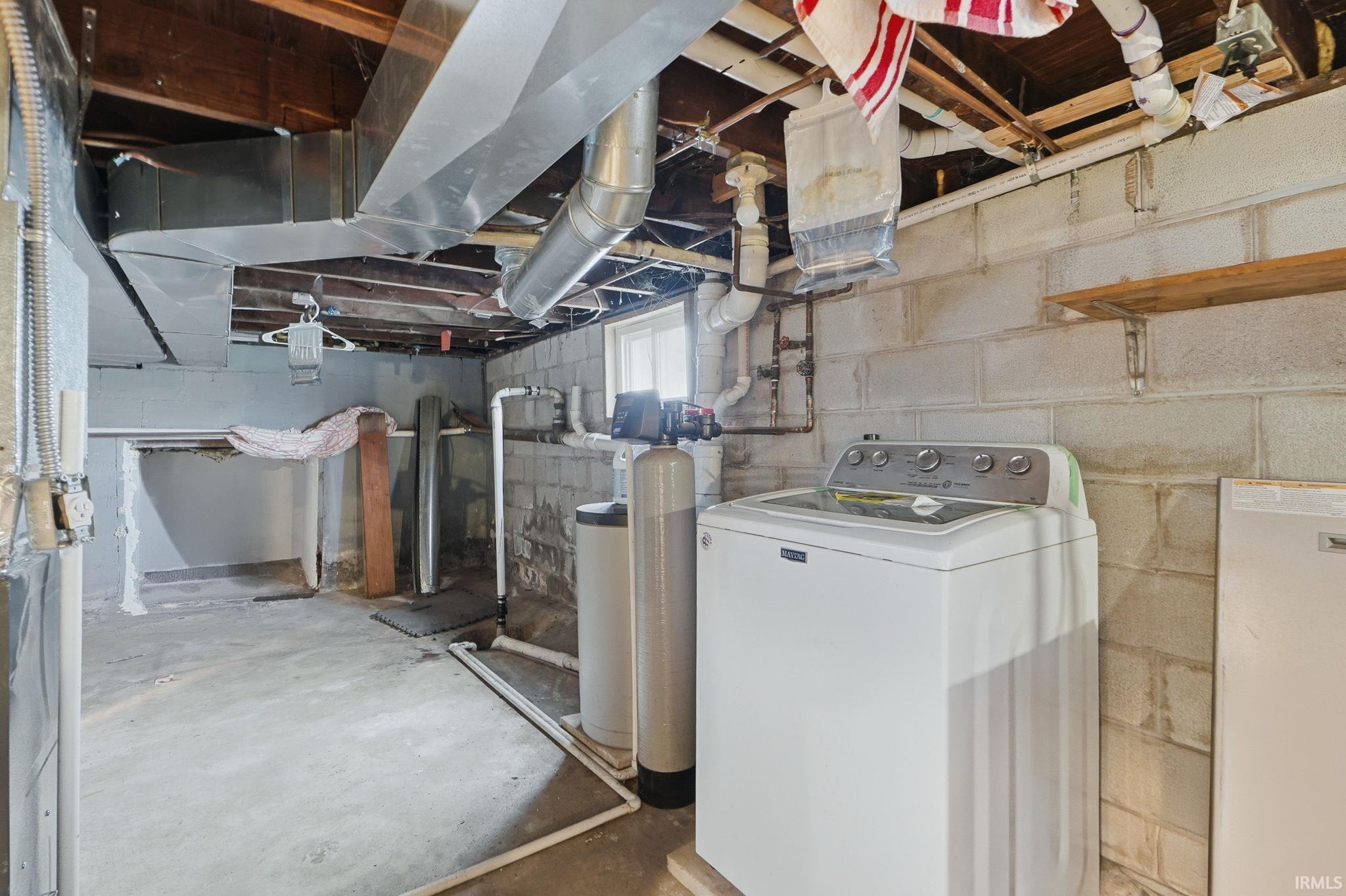 Basement featuring washer / clothes dryer and a water softener system