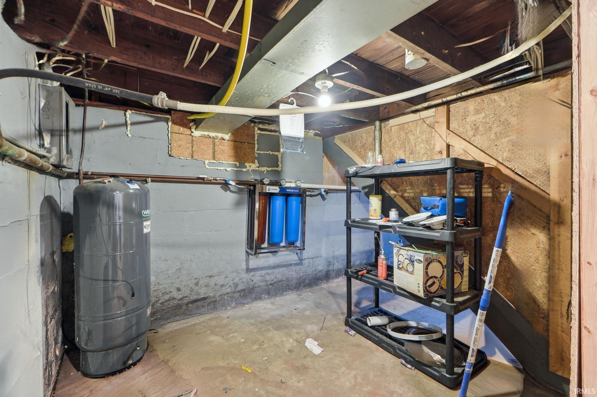 Unfinished basement featuring a water pressure tank
